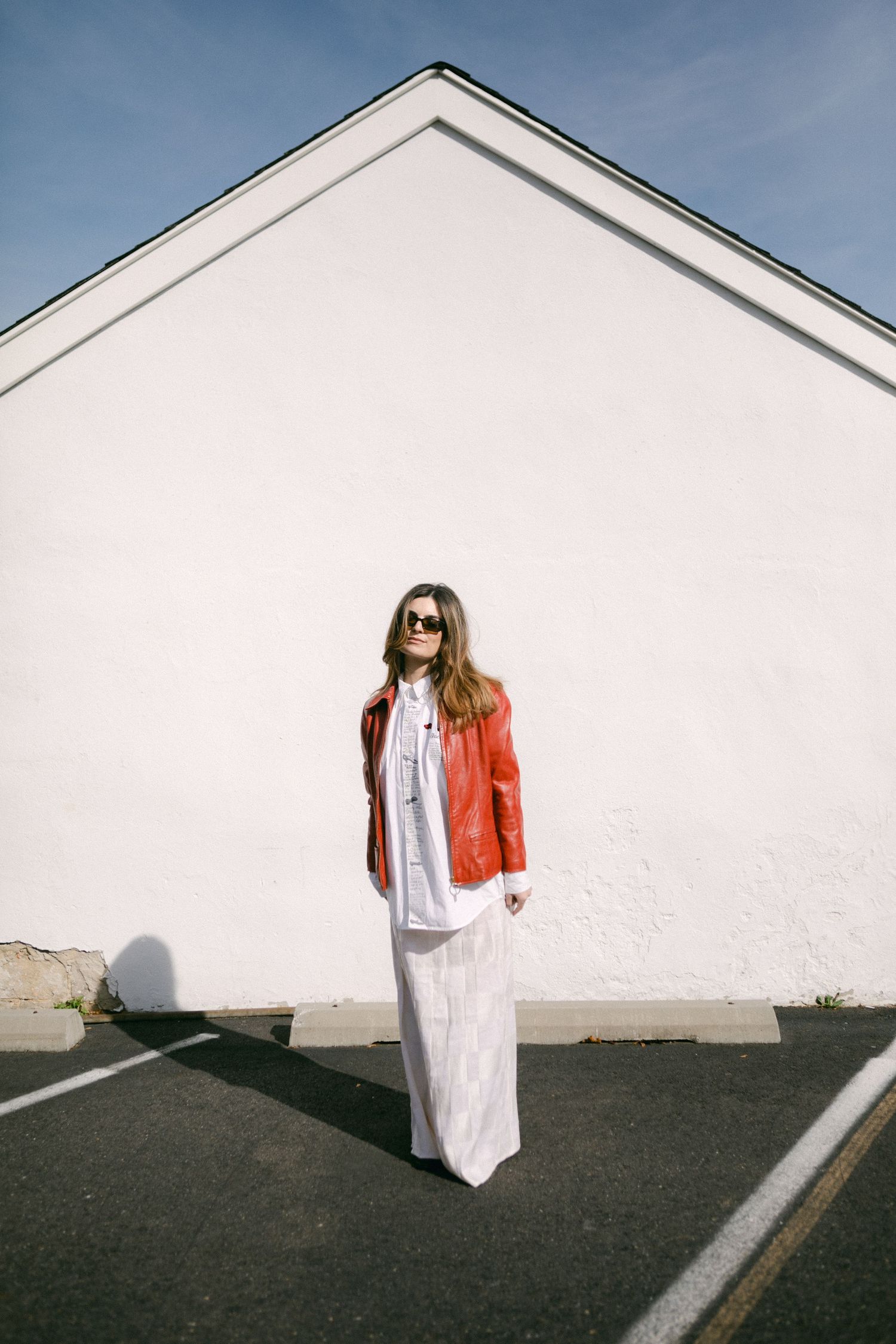 A minimalist photo series against a white wall showing movement and fashion in bright sunlight.