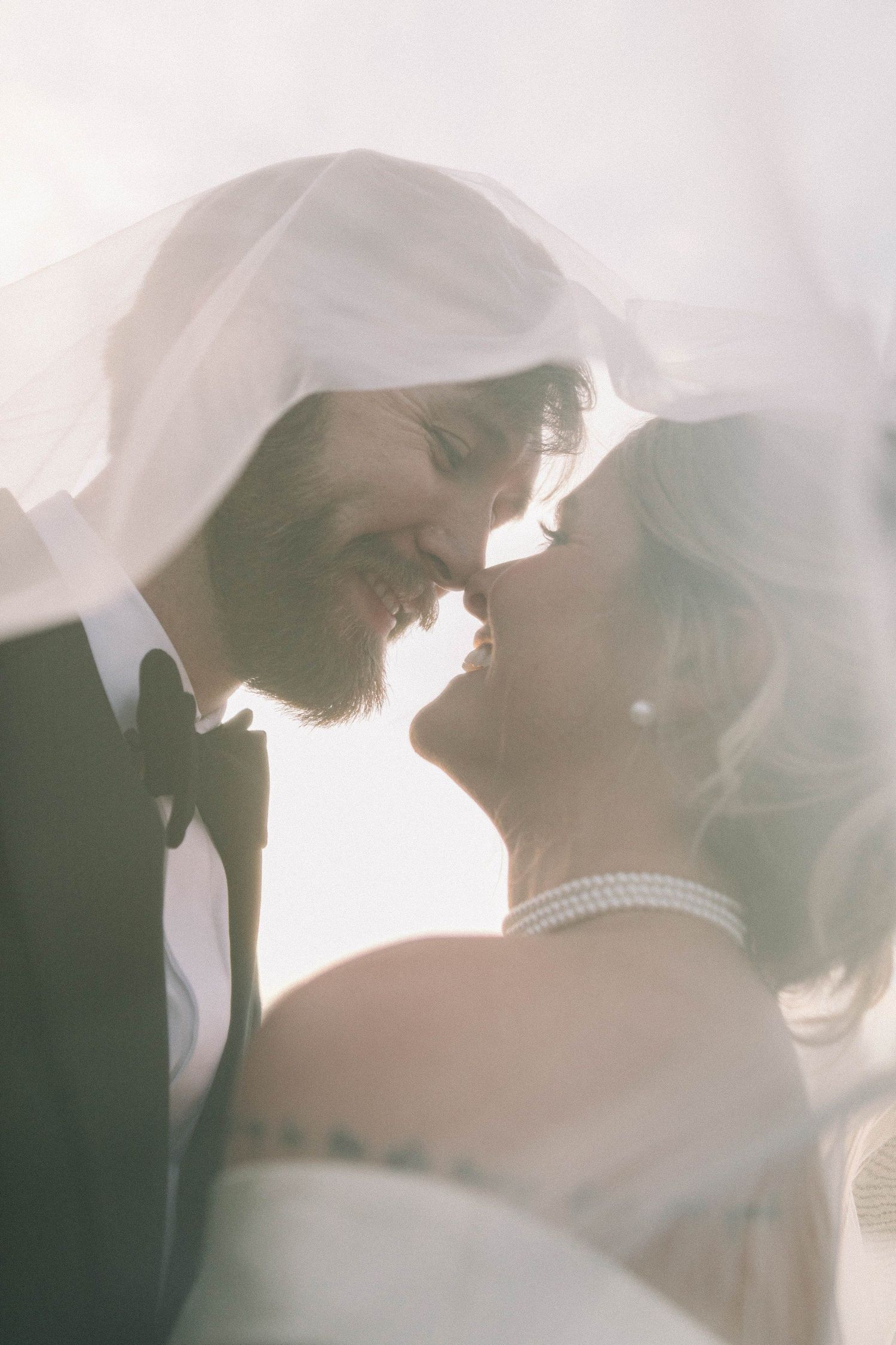 Romantic silhouette of couple embracing with sunlight creating a dreamy backlit effect.