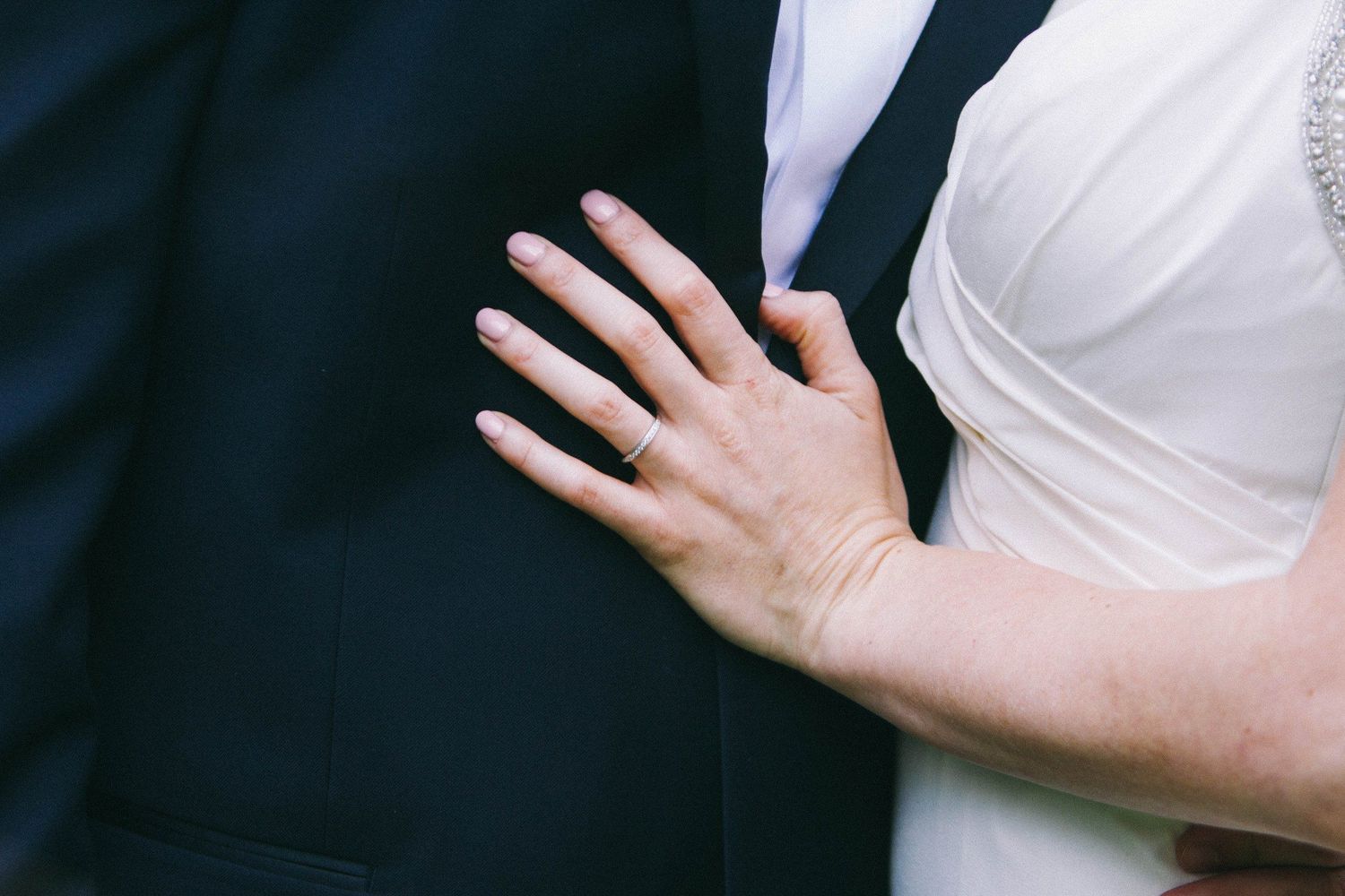 Close-up details of white fabric with hands showing texture and movement.