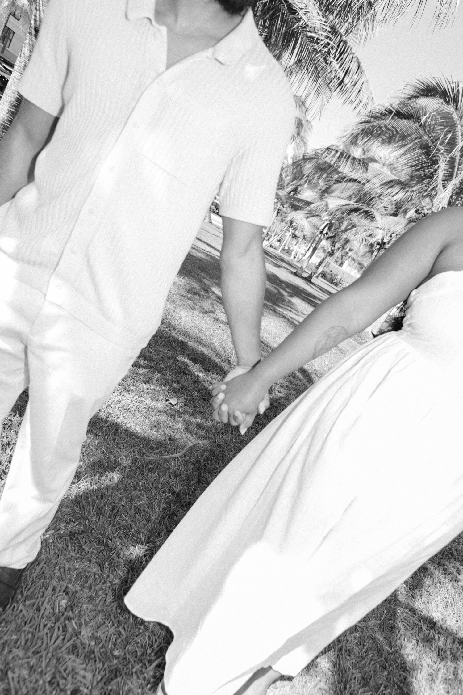 Black and white photos of couple in white outfits walking through garden setting.