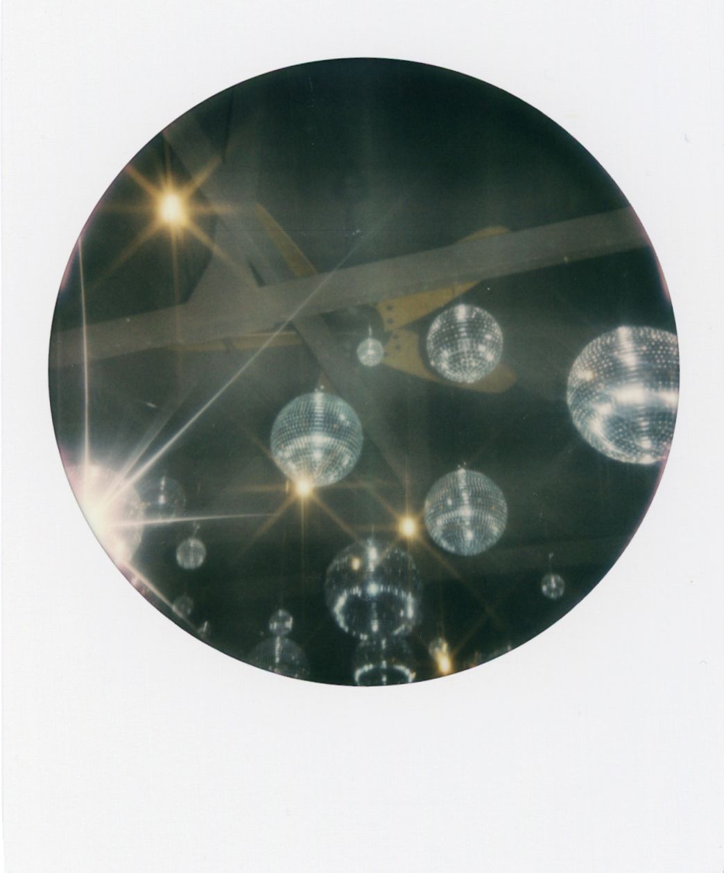Disco balls and lighting effects create a sparkling atmosphere in a dark venue.