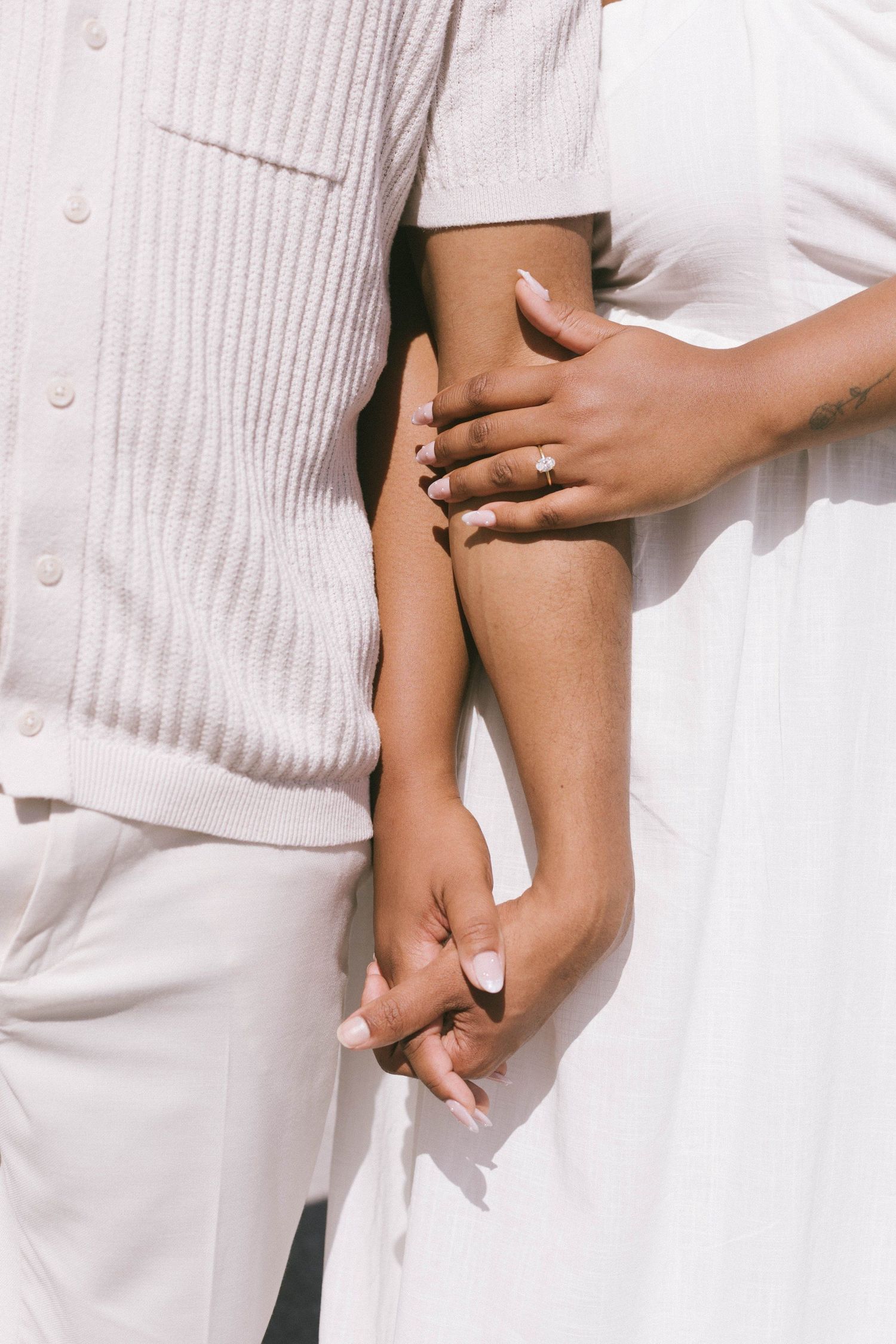 Intimate close-up shots of hands and embraces in all white attire.