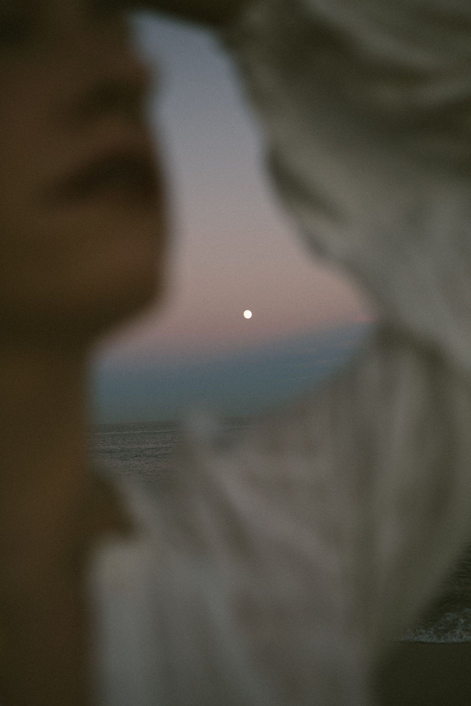 Blurred abstract landscape photo with a soft glow in the distance.
