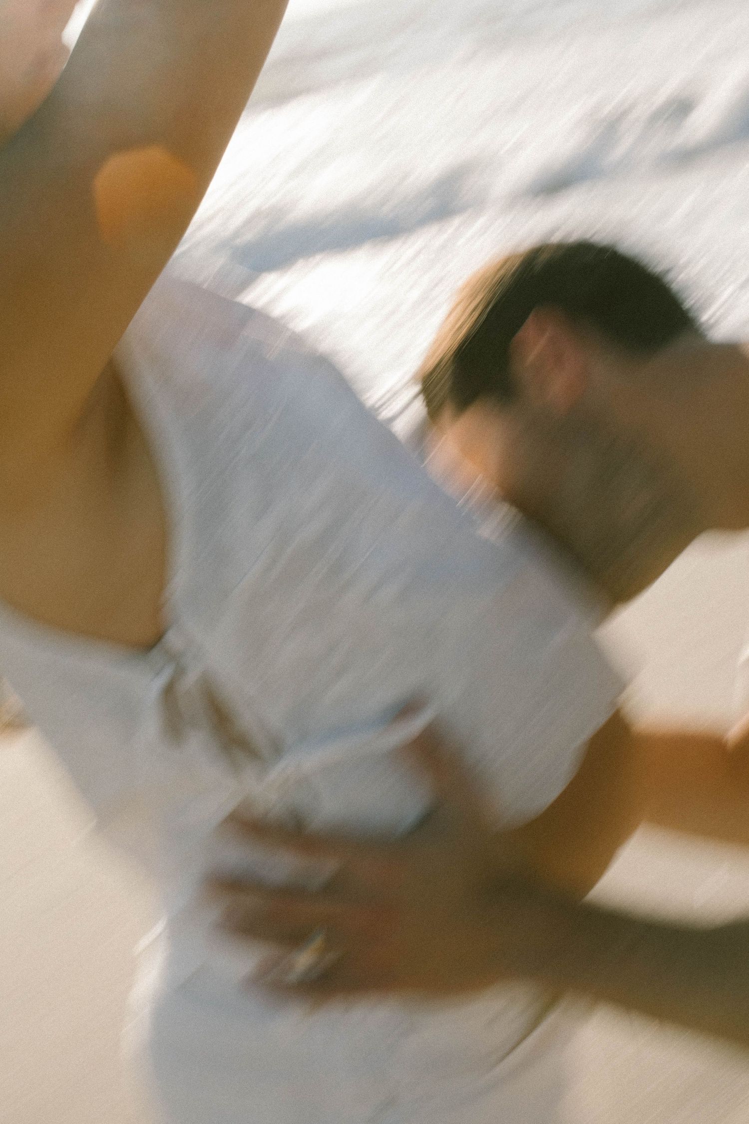 Abstract blurred motion photography of person in white clothing.