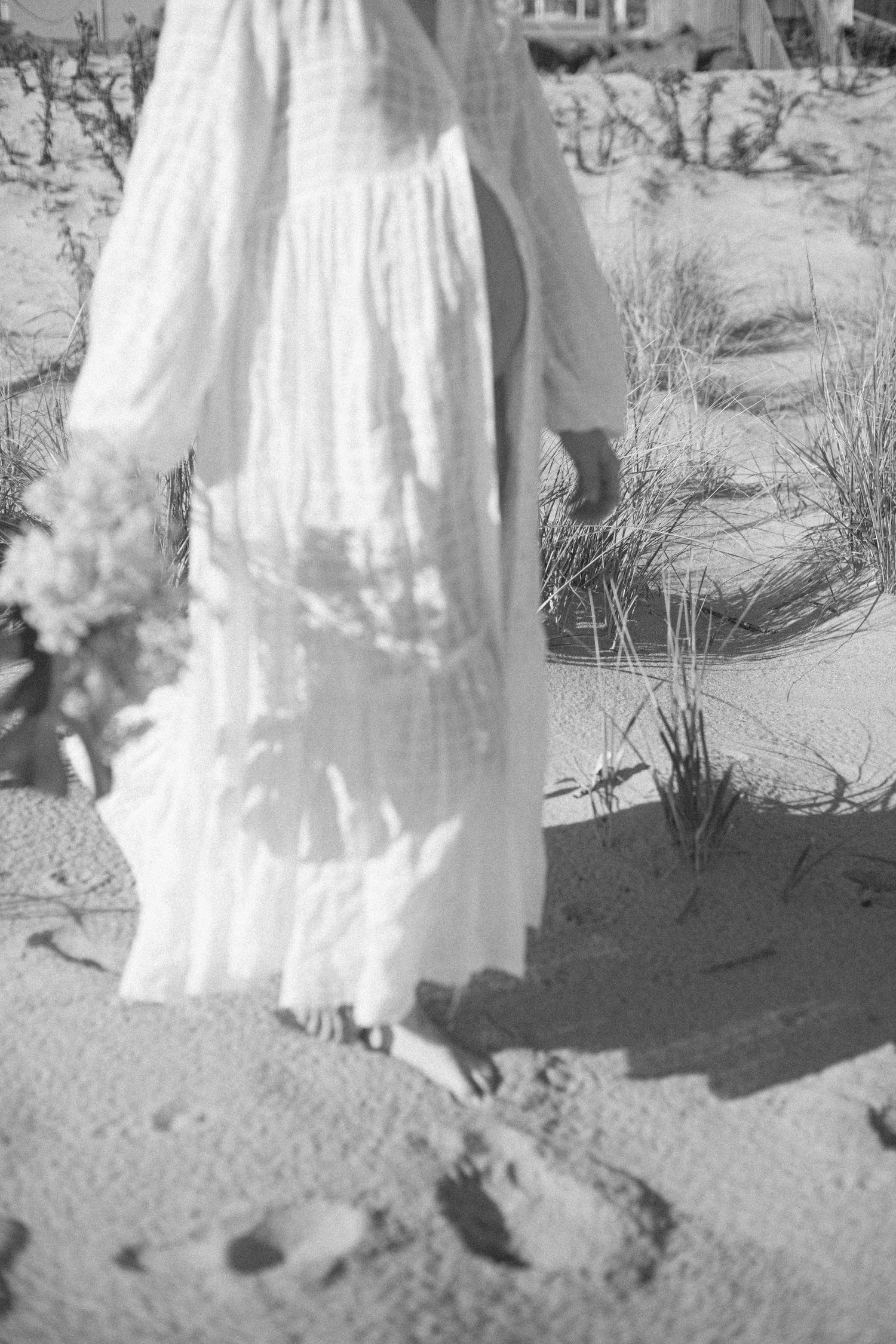Series of white vintage dress details photographed on sandy ground.