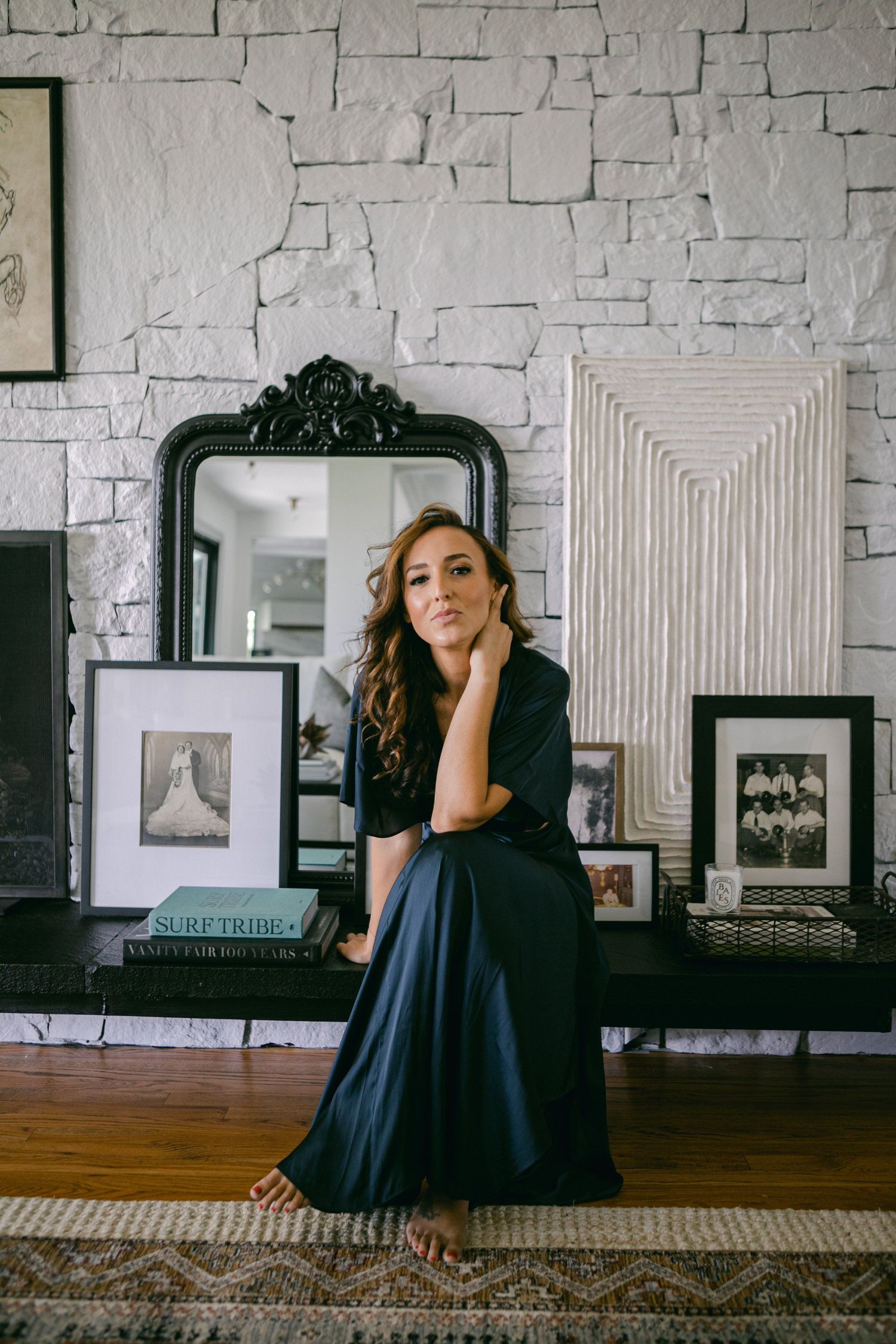 Artistic portrait series against white stone wall with framed artwork and modern decor.