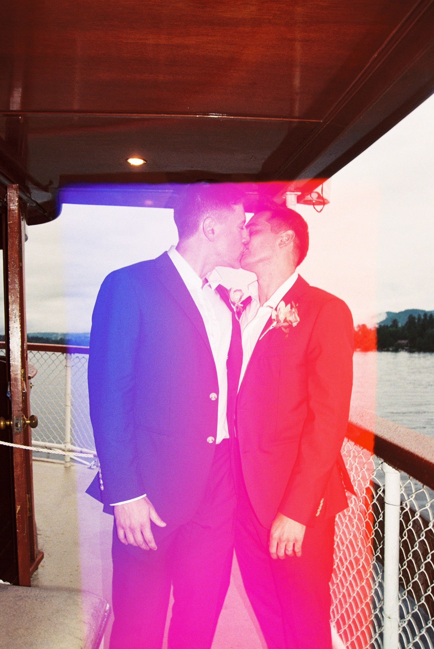 Wedding couple on a boat dock with colorful red and blue lighting effects.