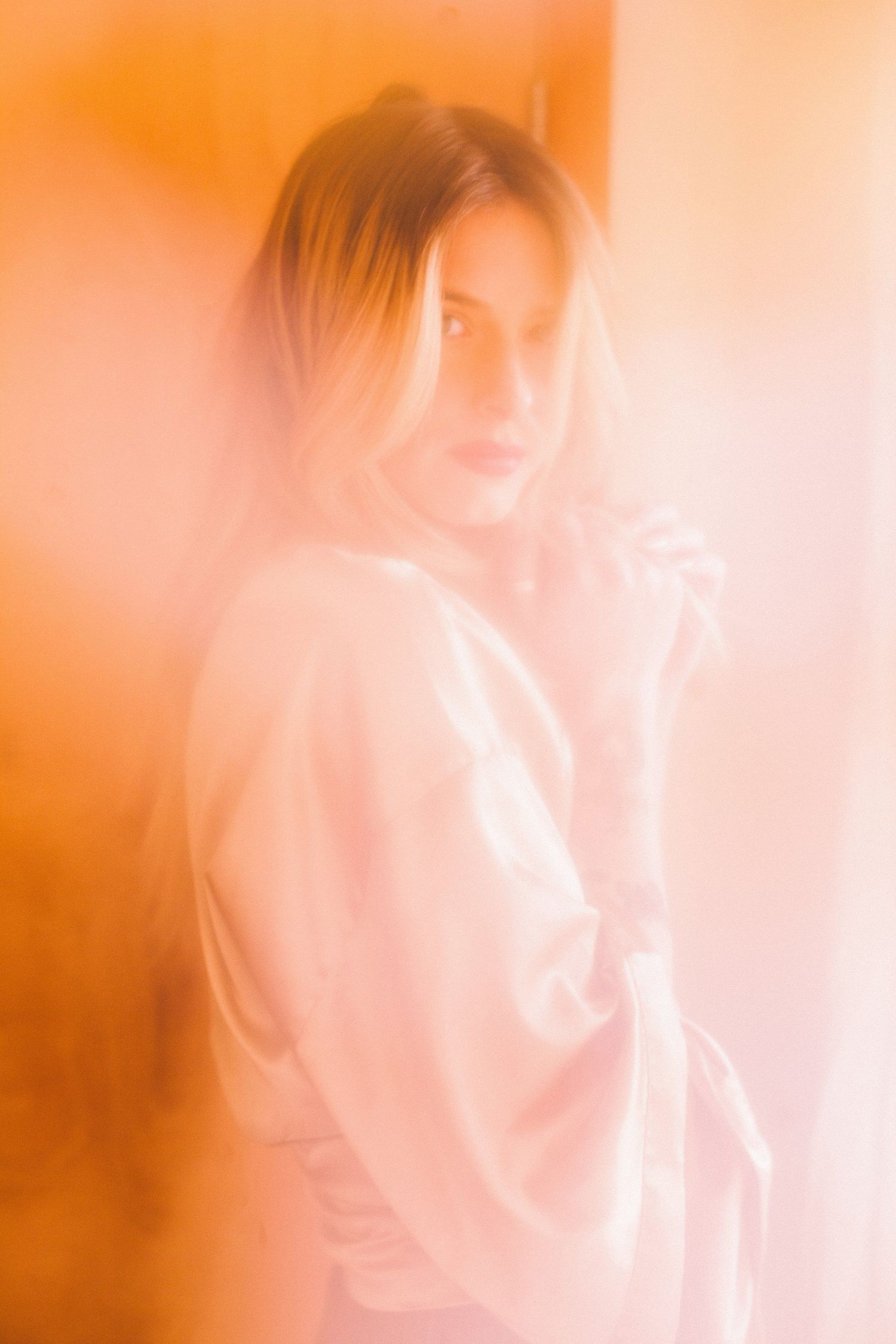 Ethereal orange-tinted portrait series with soft focus and dreamy lighting.