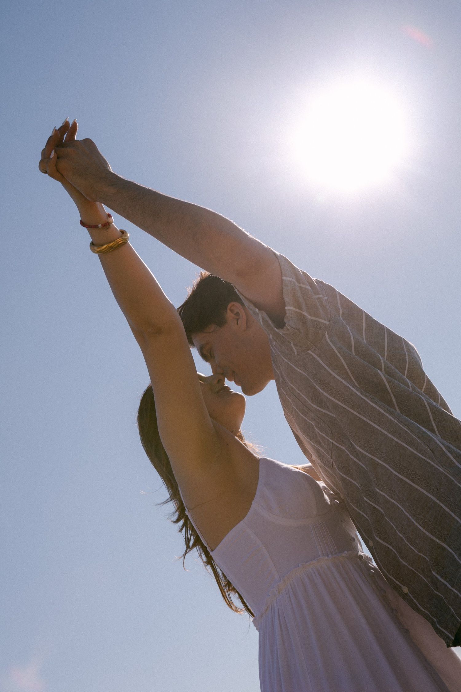 Silhouettes reaching upward against bright sunlight in a dynamic motion sequence.