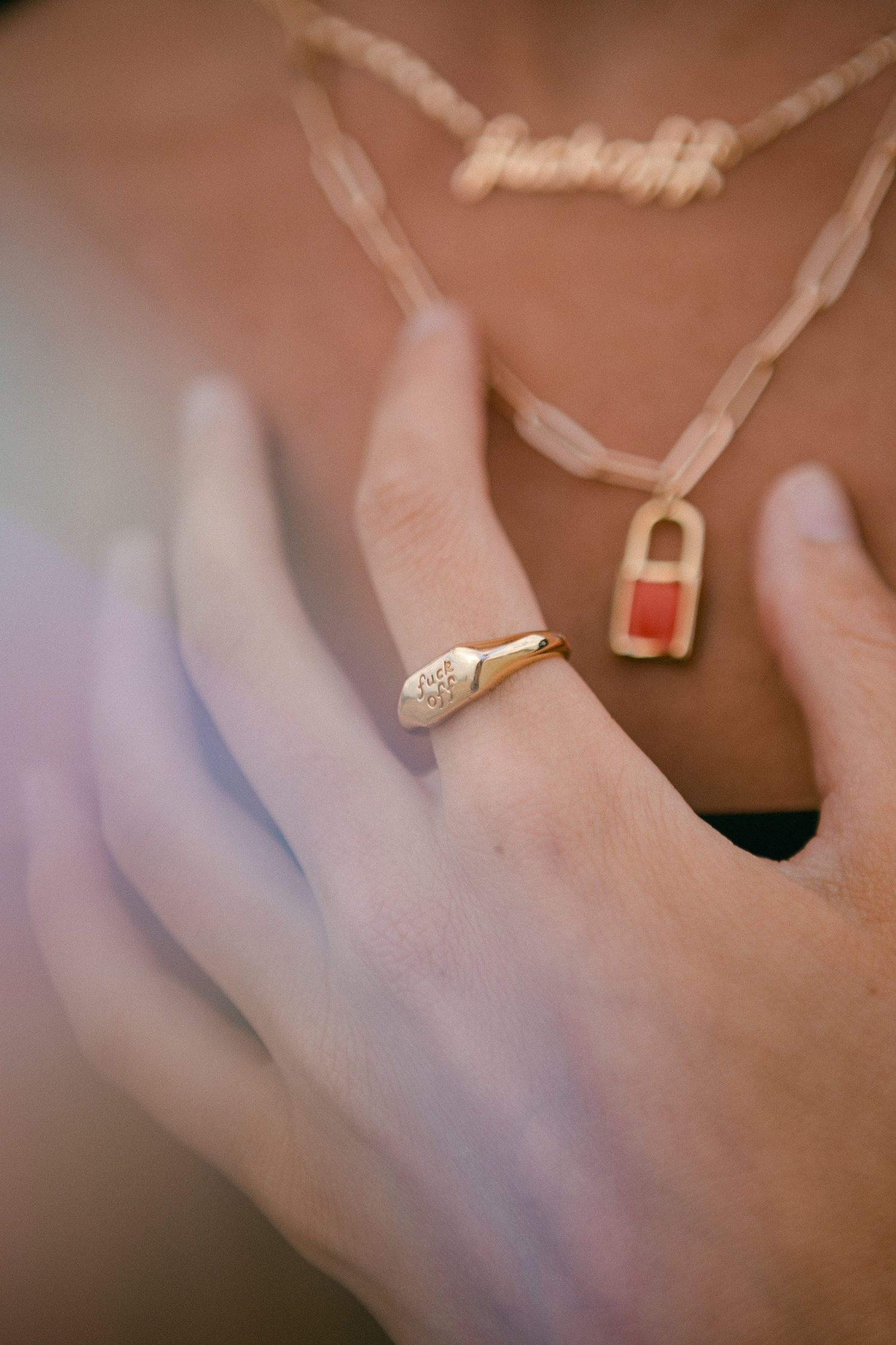 Close-up detail of delicate necklace and jewelry against skin.