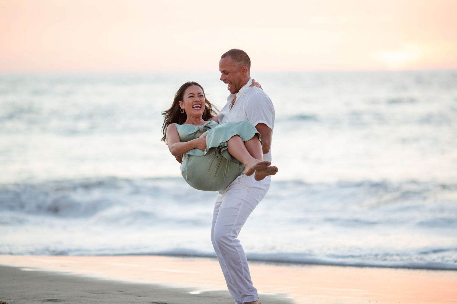 Maternity photography session at the Conrad Punta Mita, Mexico, capturing an expectant couple embracing on the beach at sunset.