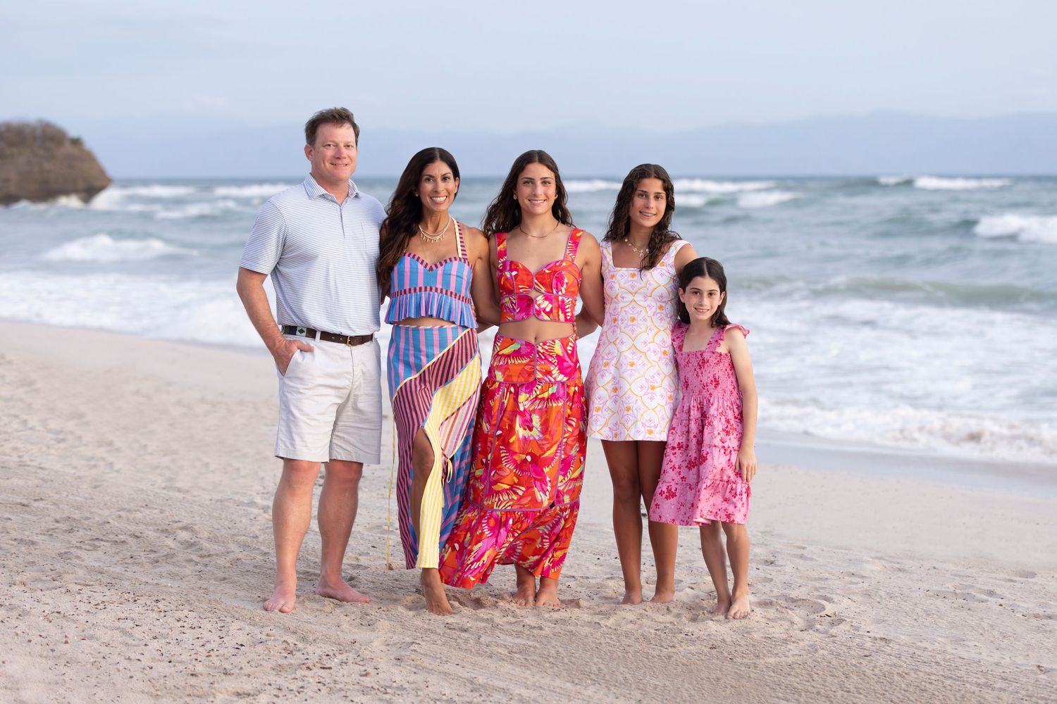 Sunset family mini photography session at Susurros del Corazón in Punta de Mita, Mexico, with parents and children posing together on the be