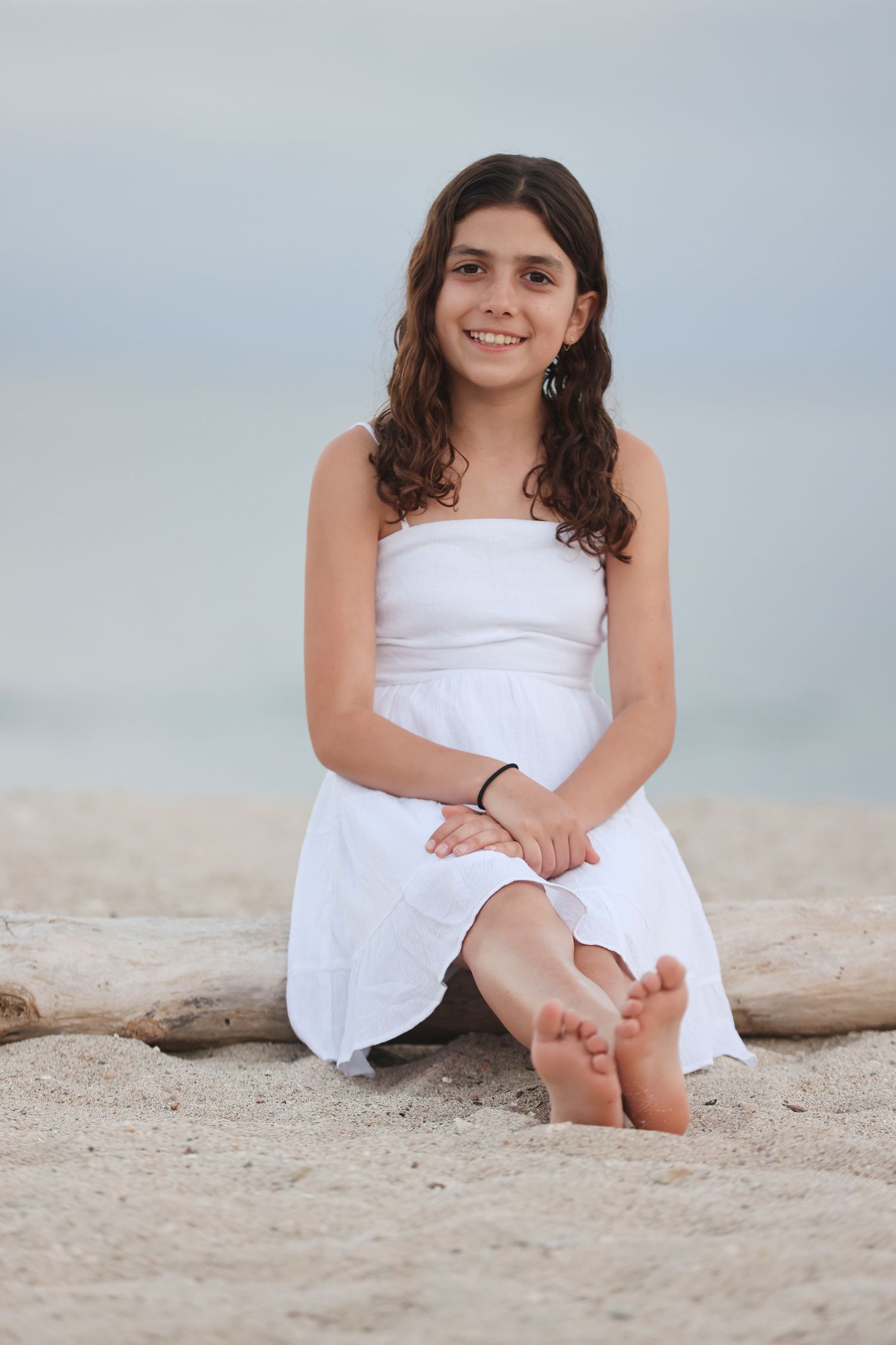 Beach portrait session at Playa Anclote, Hacienda Punta Mita, Mexico, featuring a young woman in a white dress.