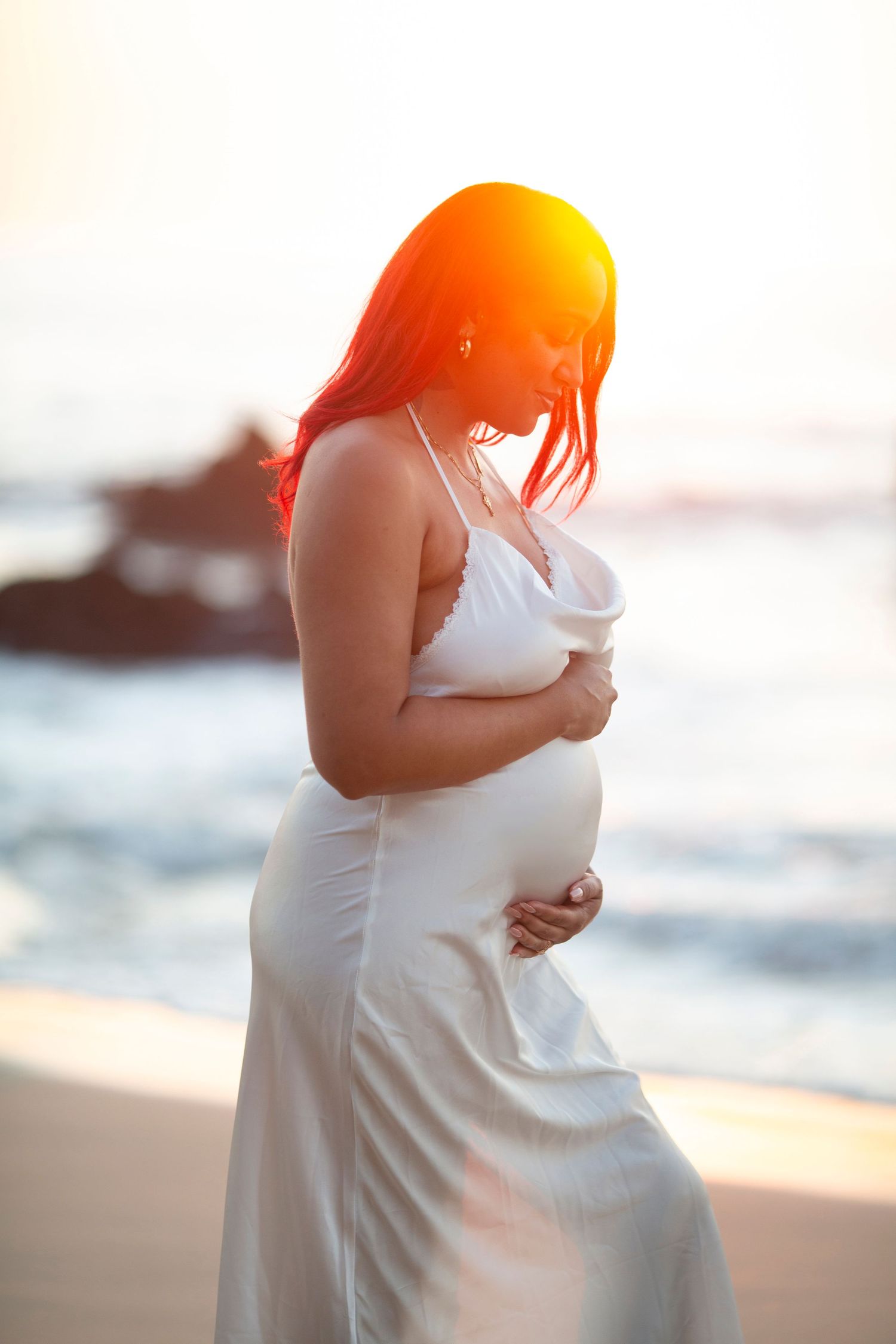 Beach maternity photography session in Sayulita, Mexico, capturing an expectant couple embracing by the ocean.