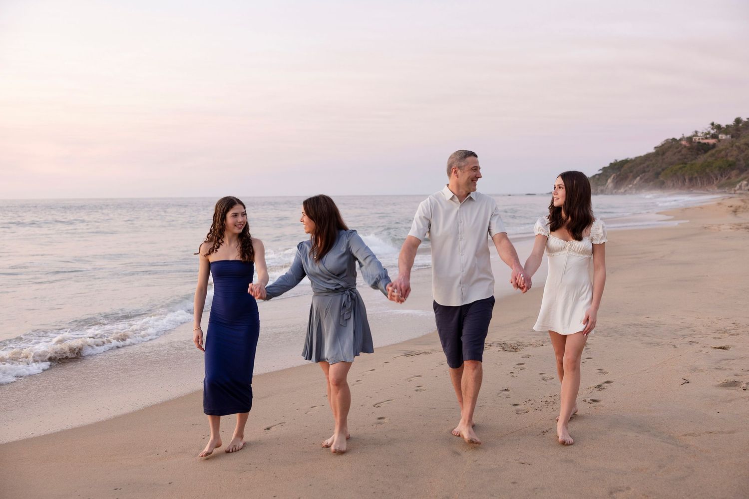 Sayulita family photographer capturing sunset beach portraits of parents and their daughters on vacation.