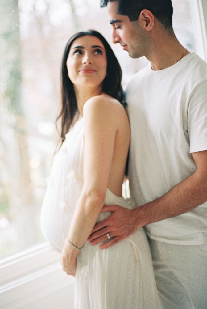 A romantic couple in white outfits embraces tenderly in a series of ethereal photos with soft natural lighting.