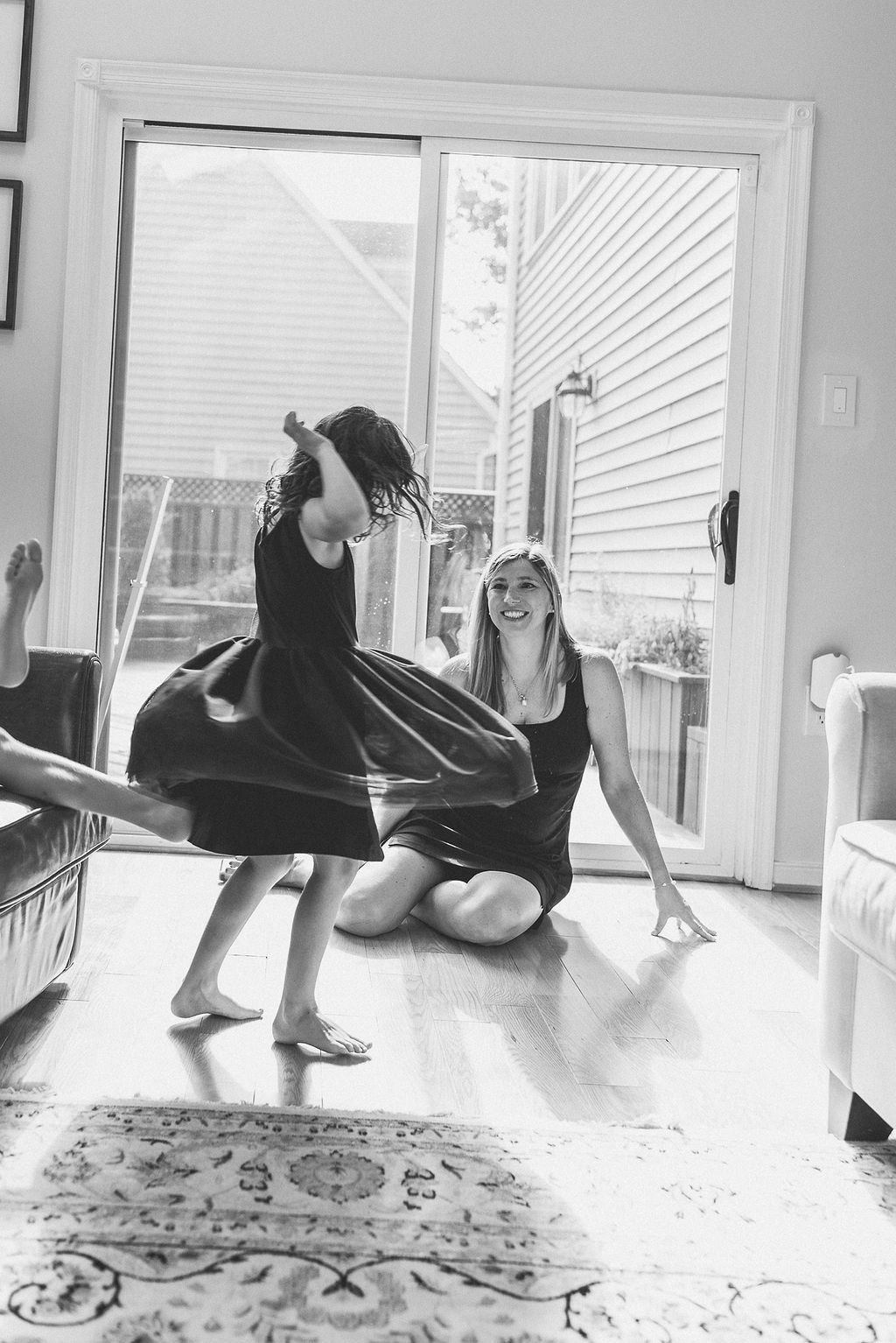 Series of artistic black and white floor poses near large windows.