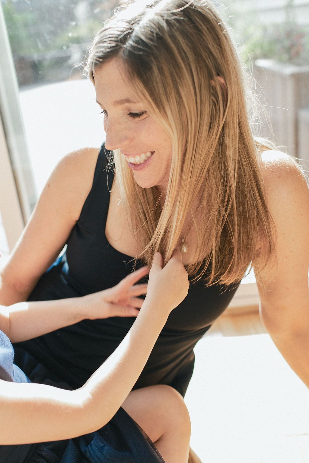 Candid lifestyle portraits showing joyful moments in bright natural window light.