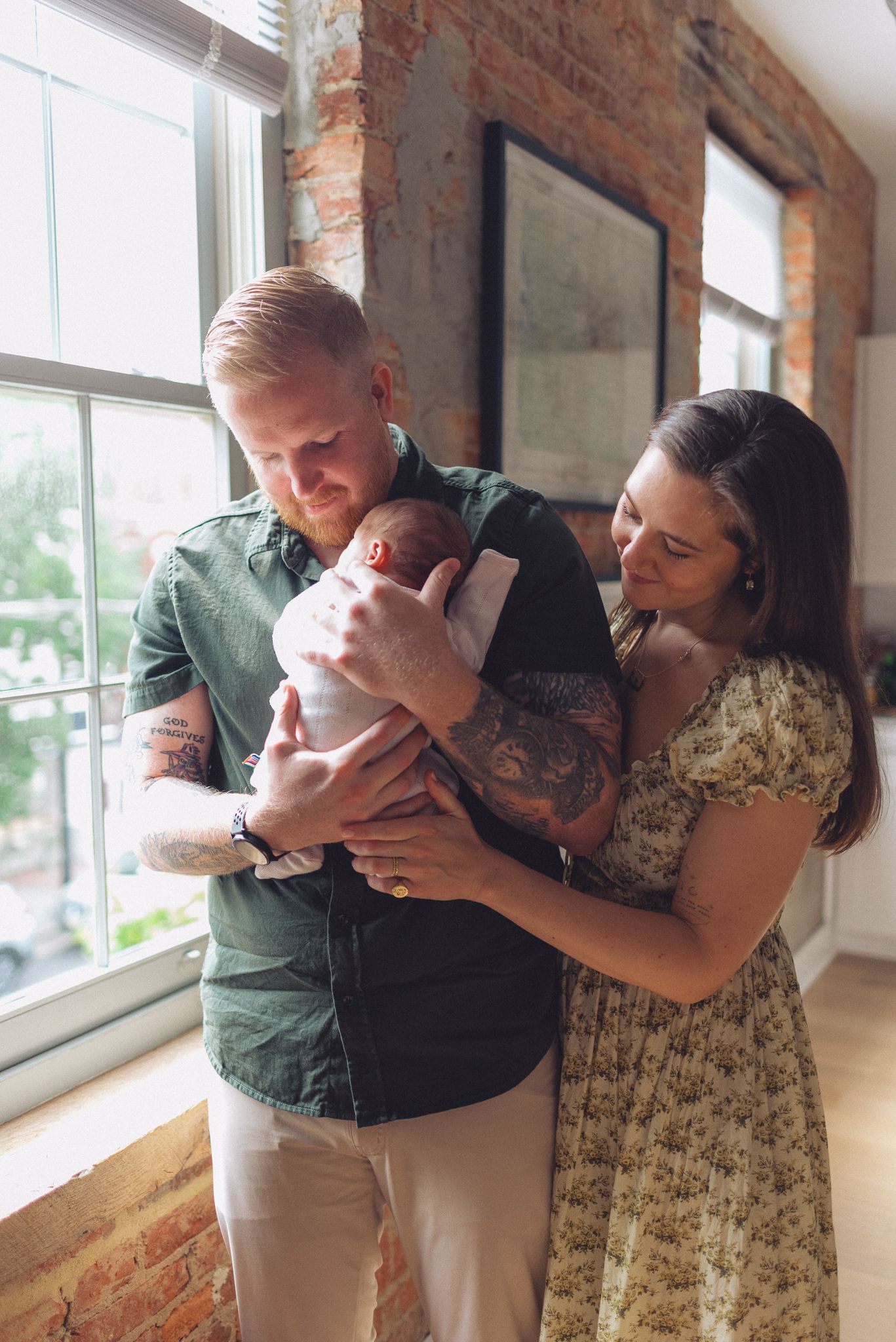 A series of four photos showing a couple embracing in a sunlit room with exposed brick walls.