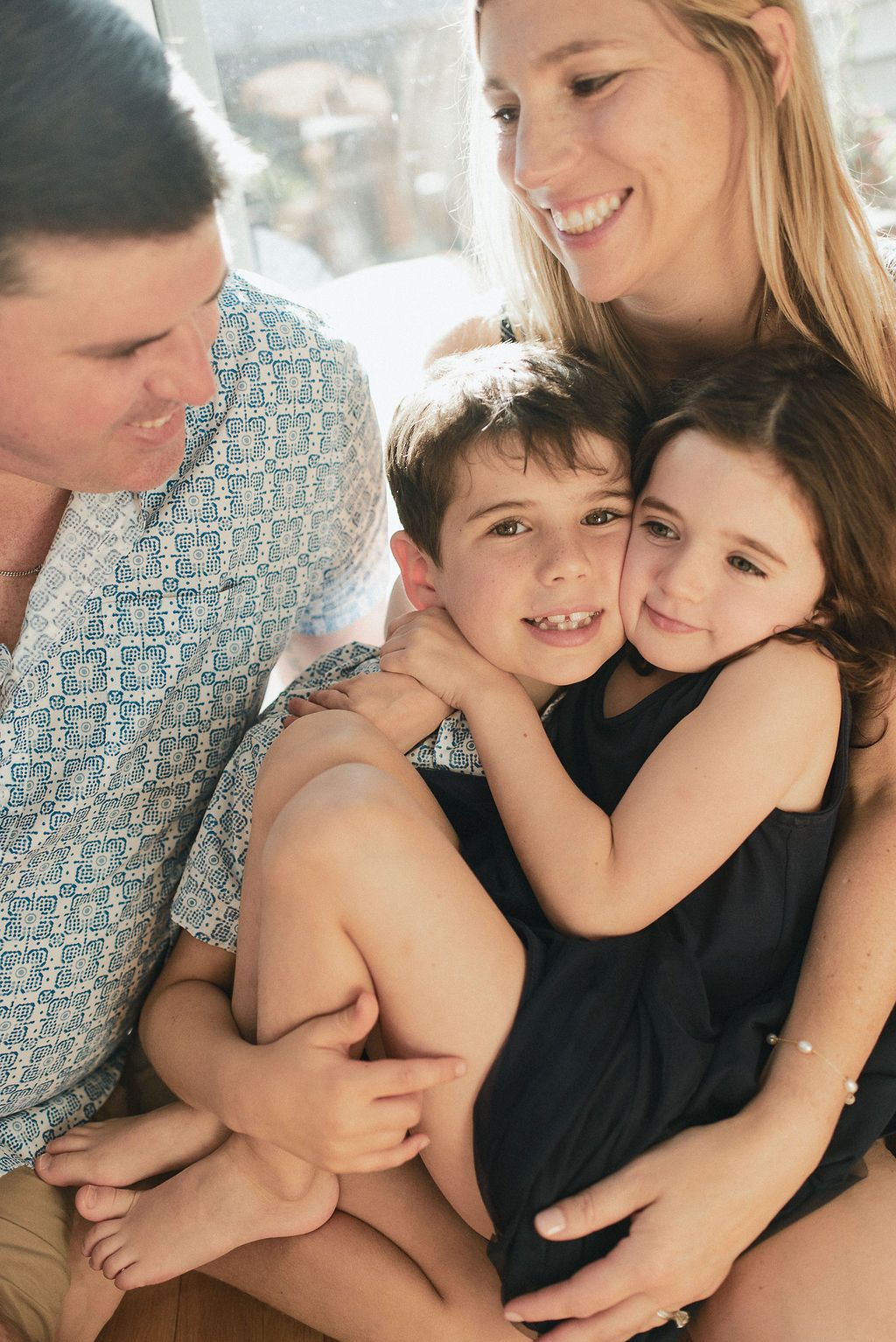 A loving family moment captured in a series of candid black and white photos showing tender embraces and smiles.