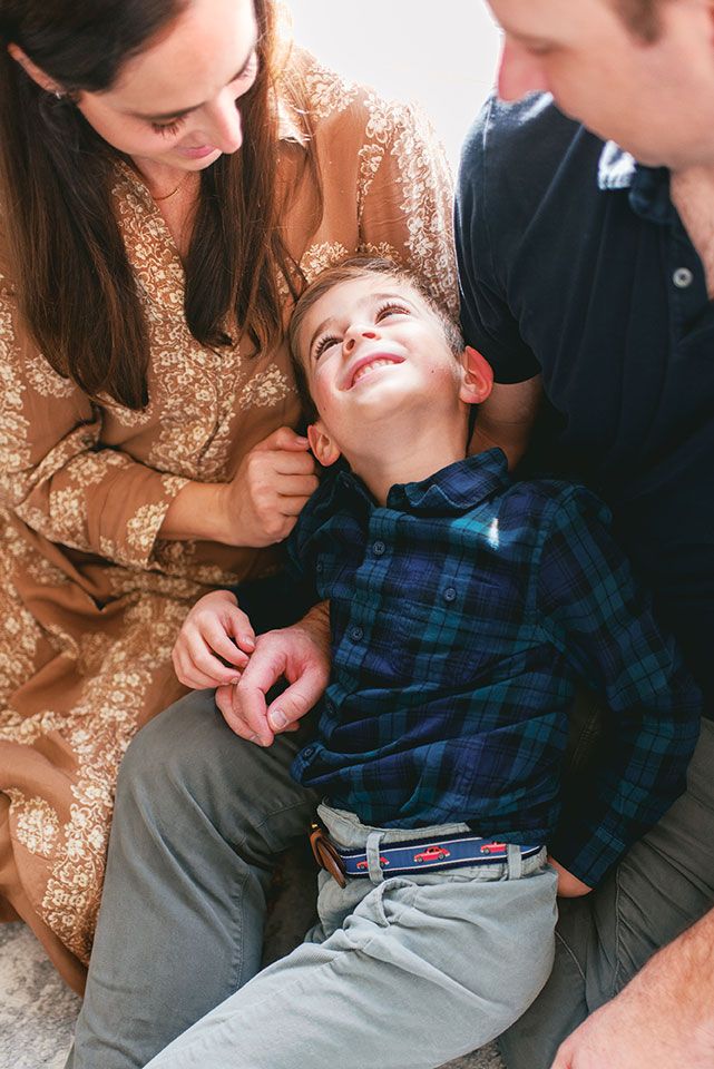 A candid family moment showing affectionate interaction and laughter while lounging together on a floor.