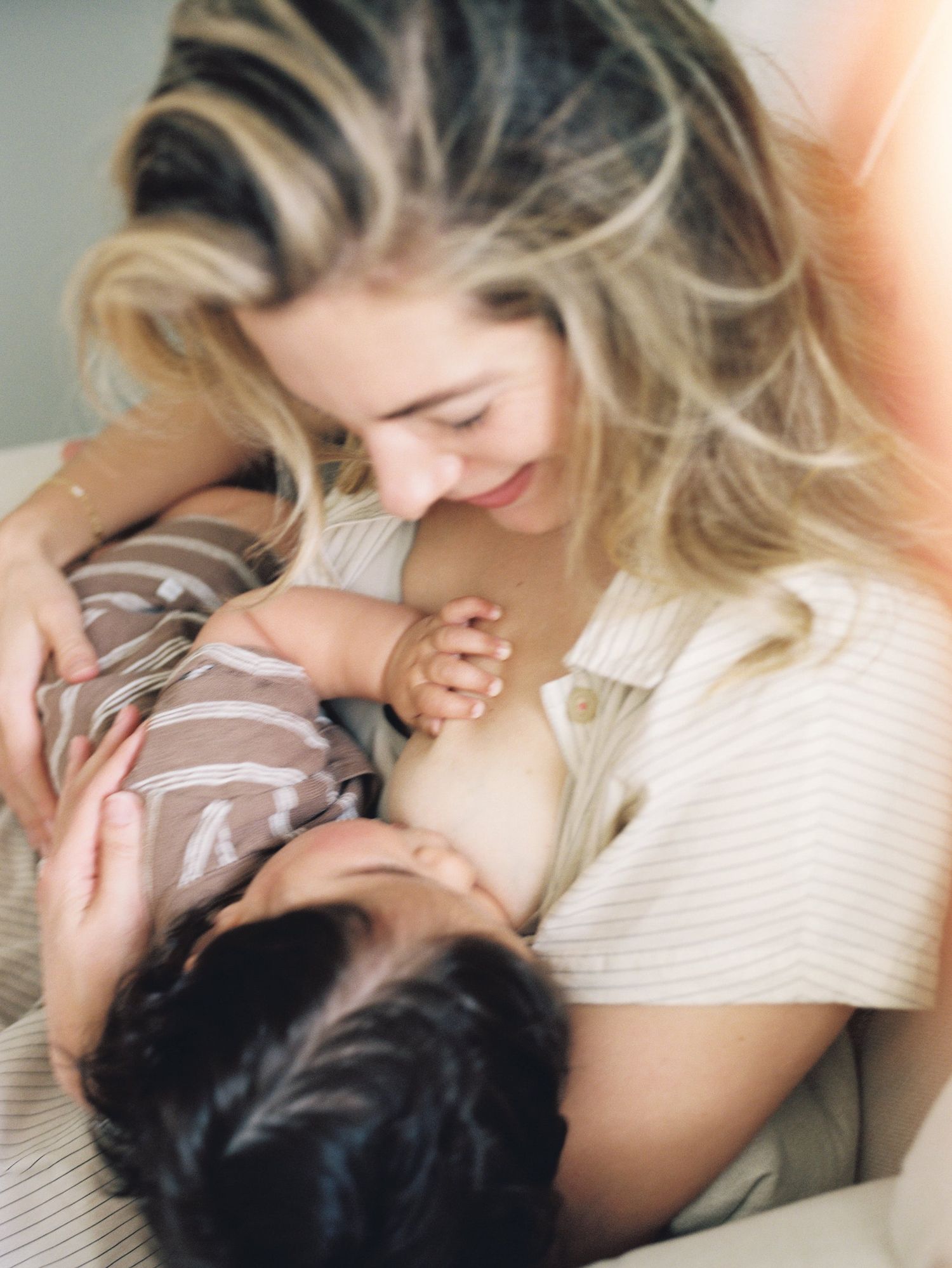 A tender parental moment captured showing affectionate interaction in soft lighting.