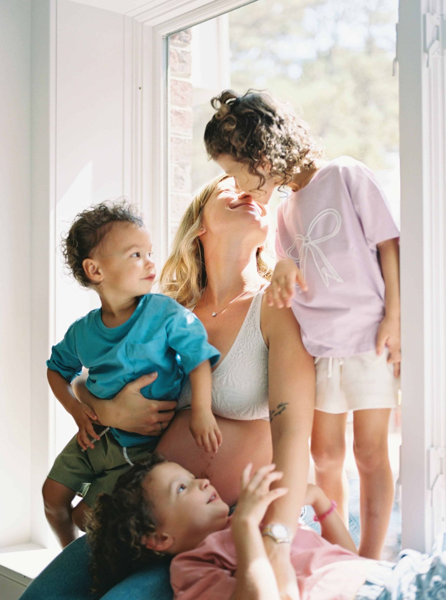 Family members in casual attire sitting together by a bright window.