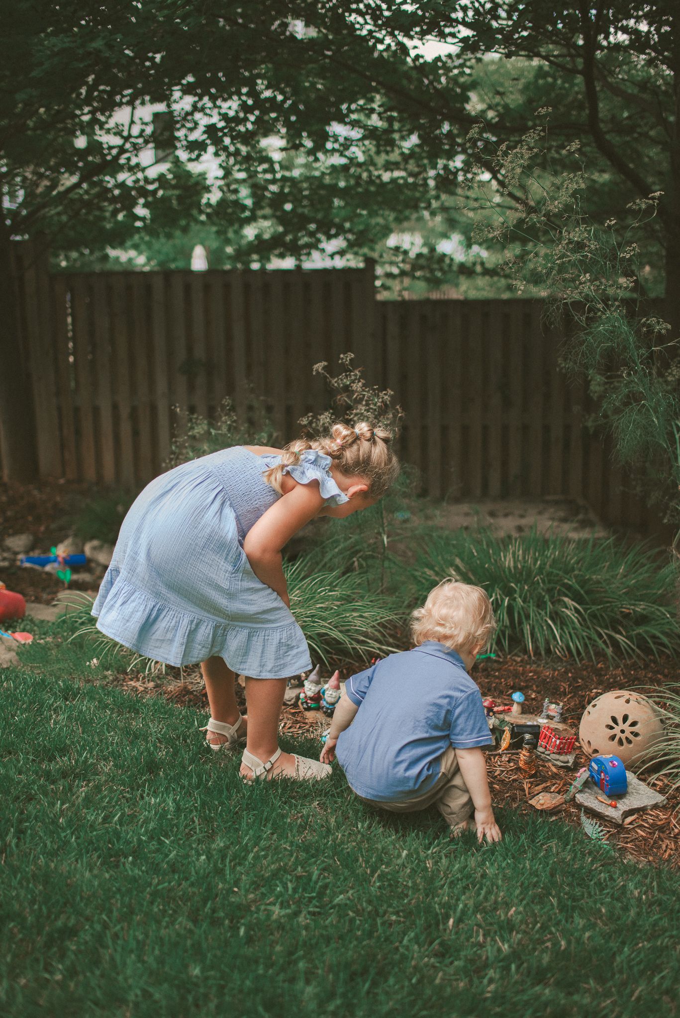 A sequence of images showing someone in a blue dress crawling on grass searching for something.