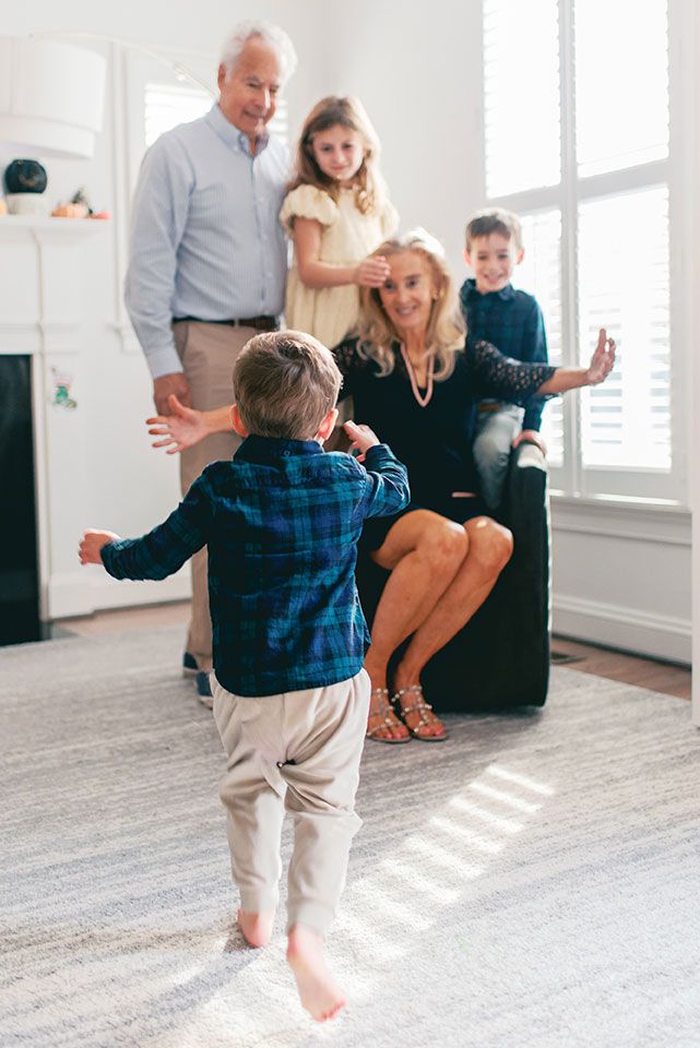 Family plays together in a bright living room with hardwood floors and white walls.