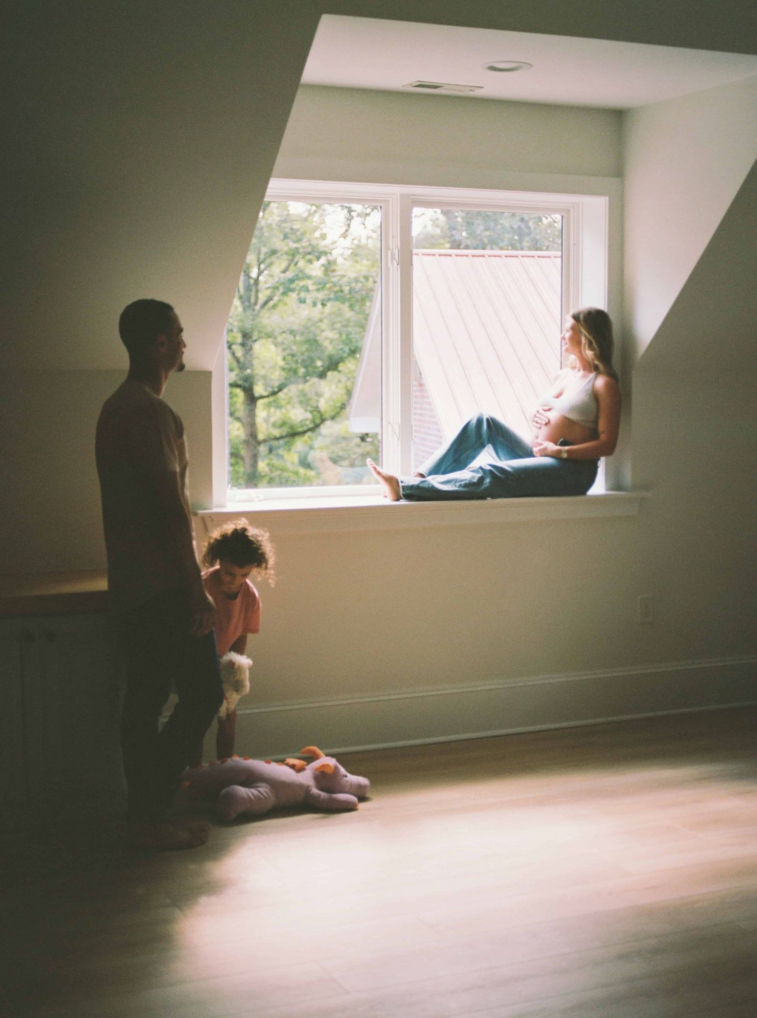 Artistic silhouette photos of figures by a window in moody lighting.