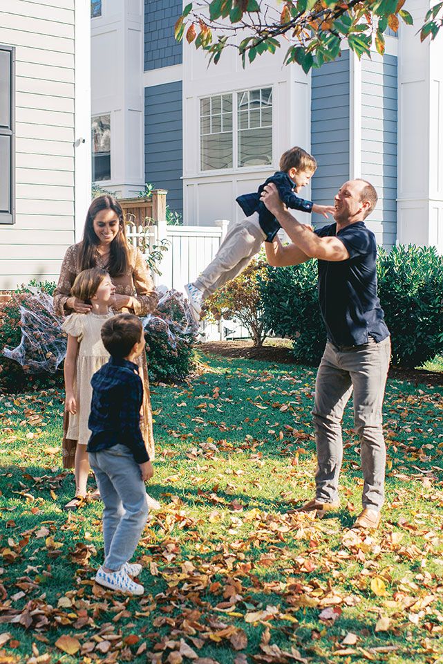 A sequence of playful moments captured in autumn as leaves scatter across a front yard on a sunny day.
