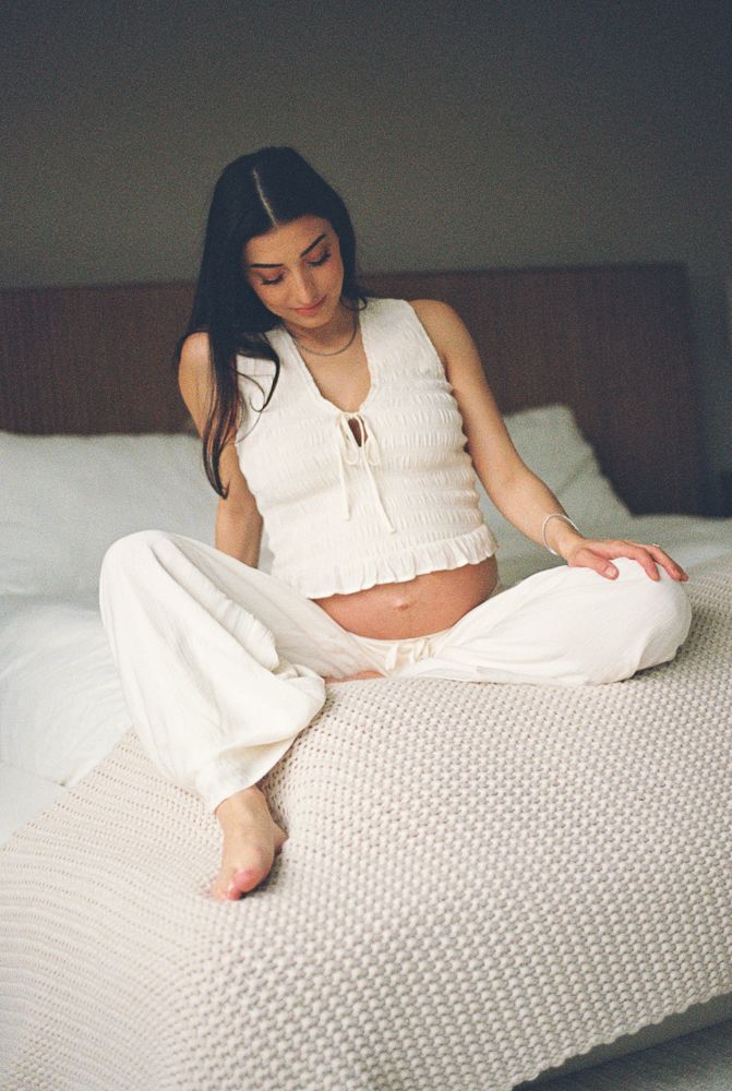 A series of minimalist boudoir photos showing a person in white loungewear reclining on textured bedding.