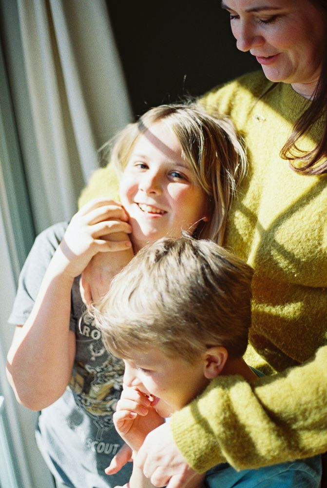 A series of candid moments showing a child and adult in a yellow sweater sharing laughter and tender interactions.