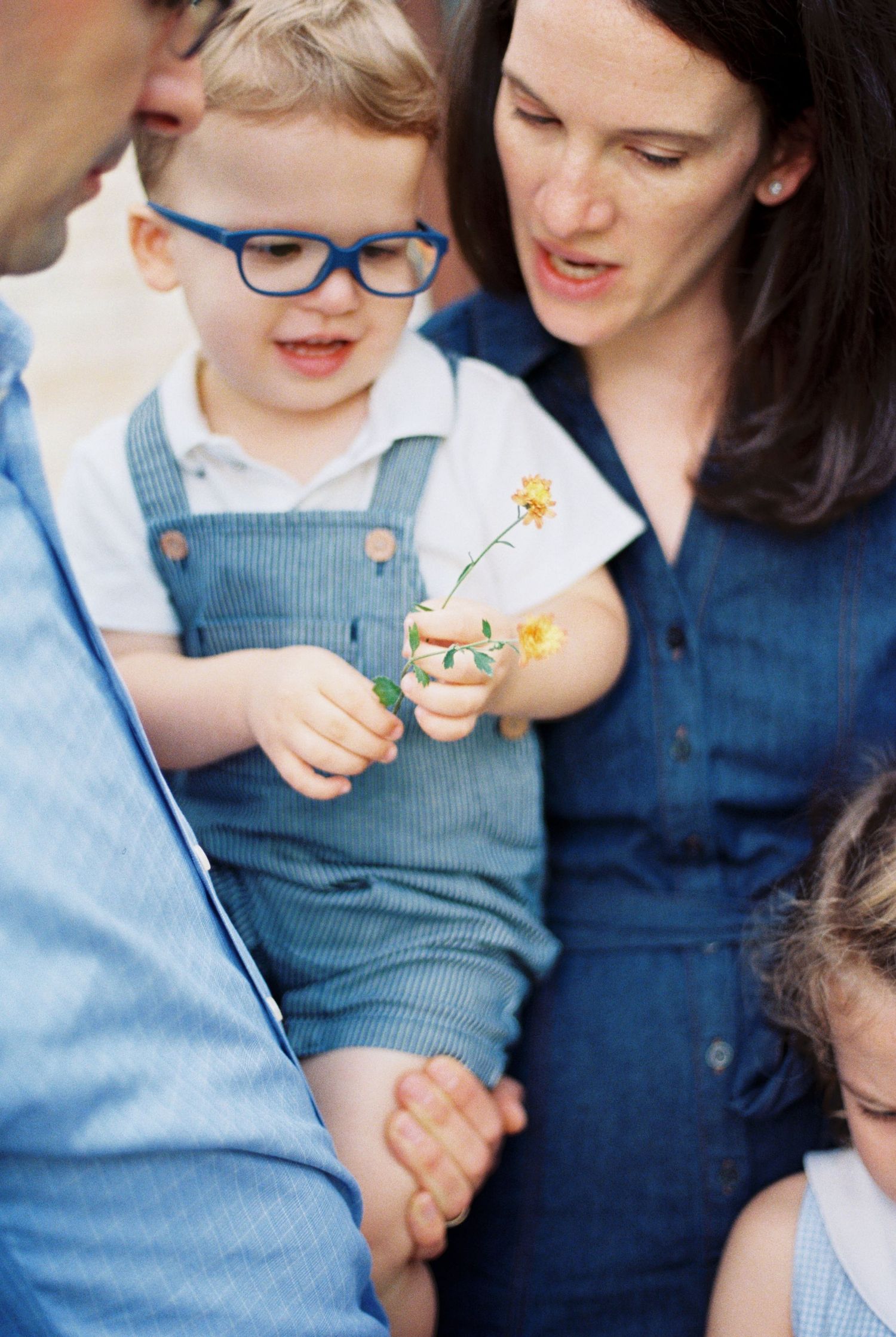 A series of candid moments showing a child in denim overalls sitting with an adult in blue denim clothing.