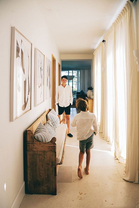A sequence of photos showing someone floating and levitating down a bright white hallway with wooden furniture.