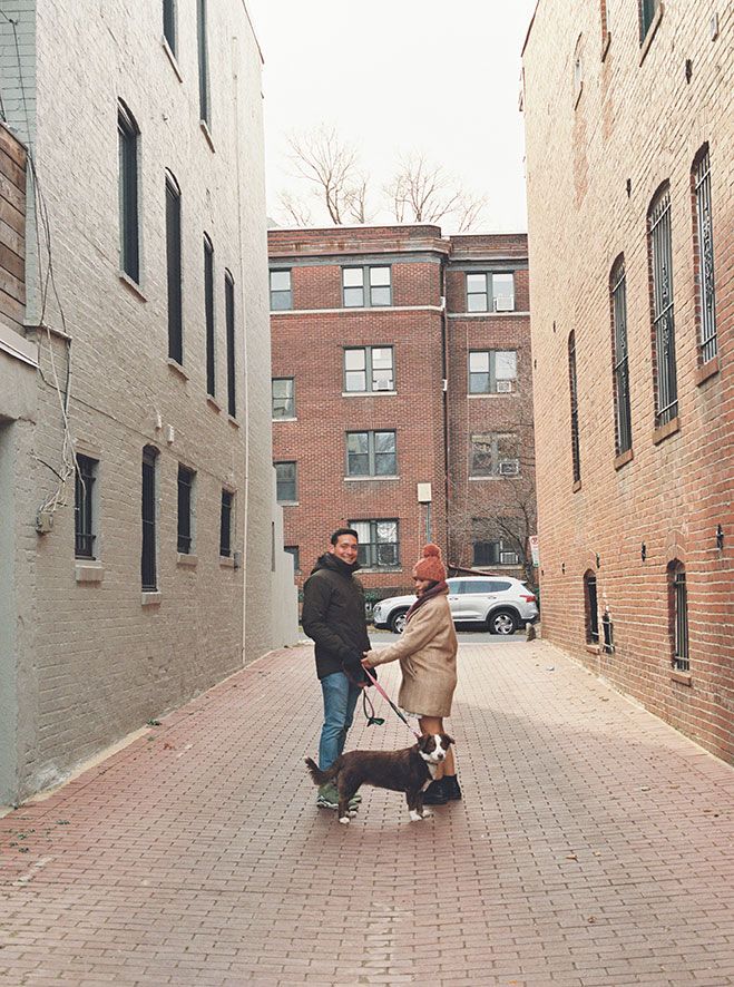 A playful sequence of dance moves between two people on a brick courtyard with buildings in the background.