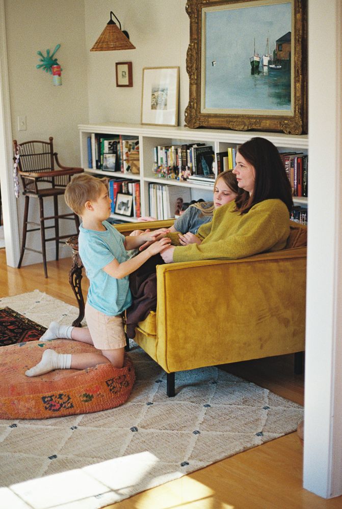 A sequence of three photos shows a young child in blue crawling towards someone sitting on a mustard yellow couch.