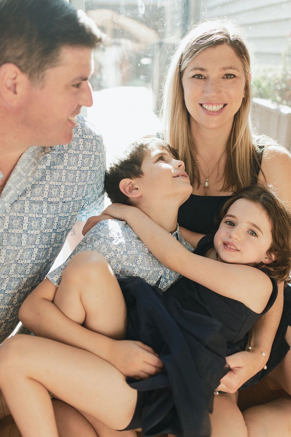 A series of warm family portraits showing affectionate moments and playful interactions in natural lighting.