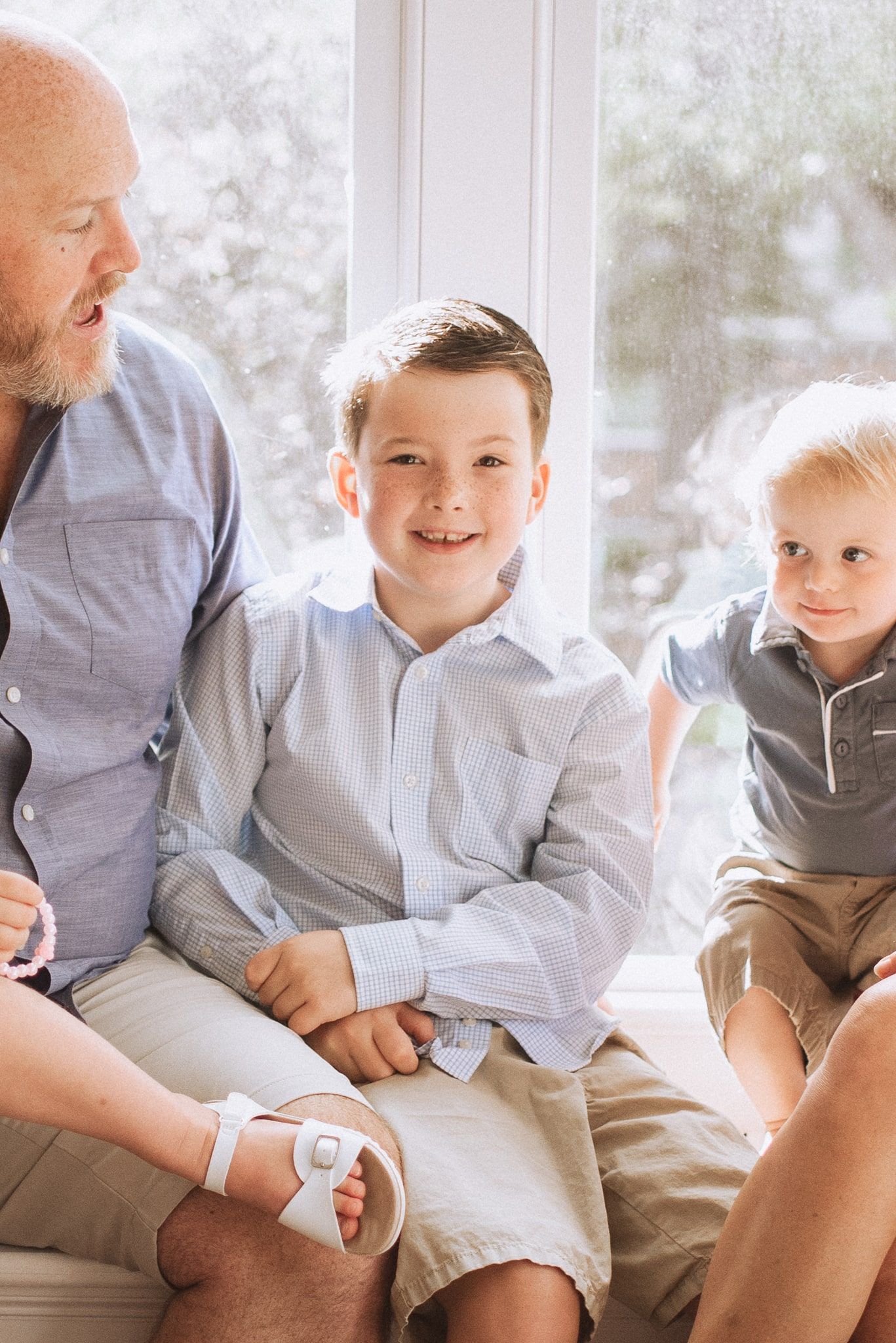 A heartwarming candid series of family moments showing tender interactions in matching light-colored clothing.