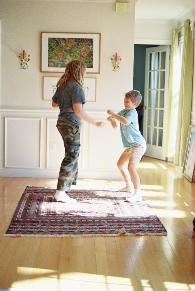 Multiple photos showing playful movement and interaction on an oriental rug in a bright interior space.