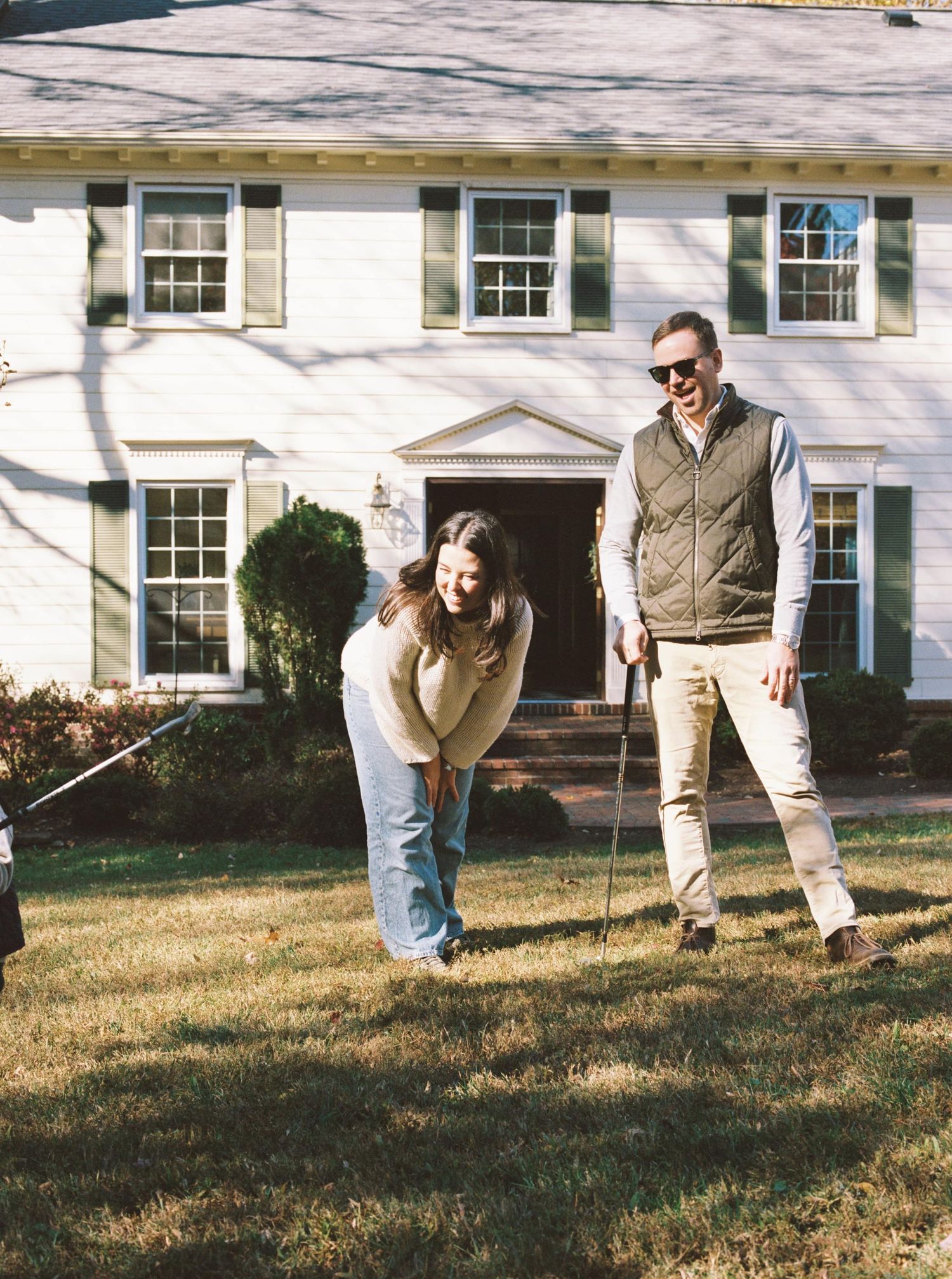 A sequence of four photos showing someone walking and falling on grass in front of a white house with windows.