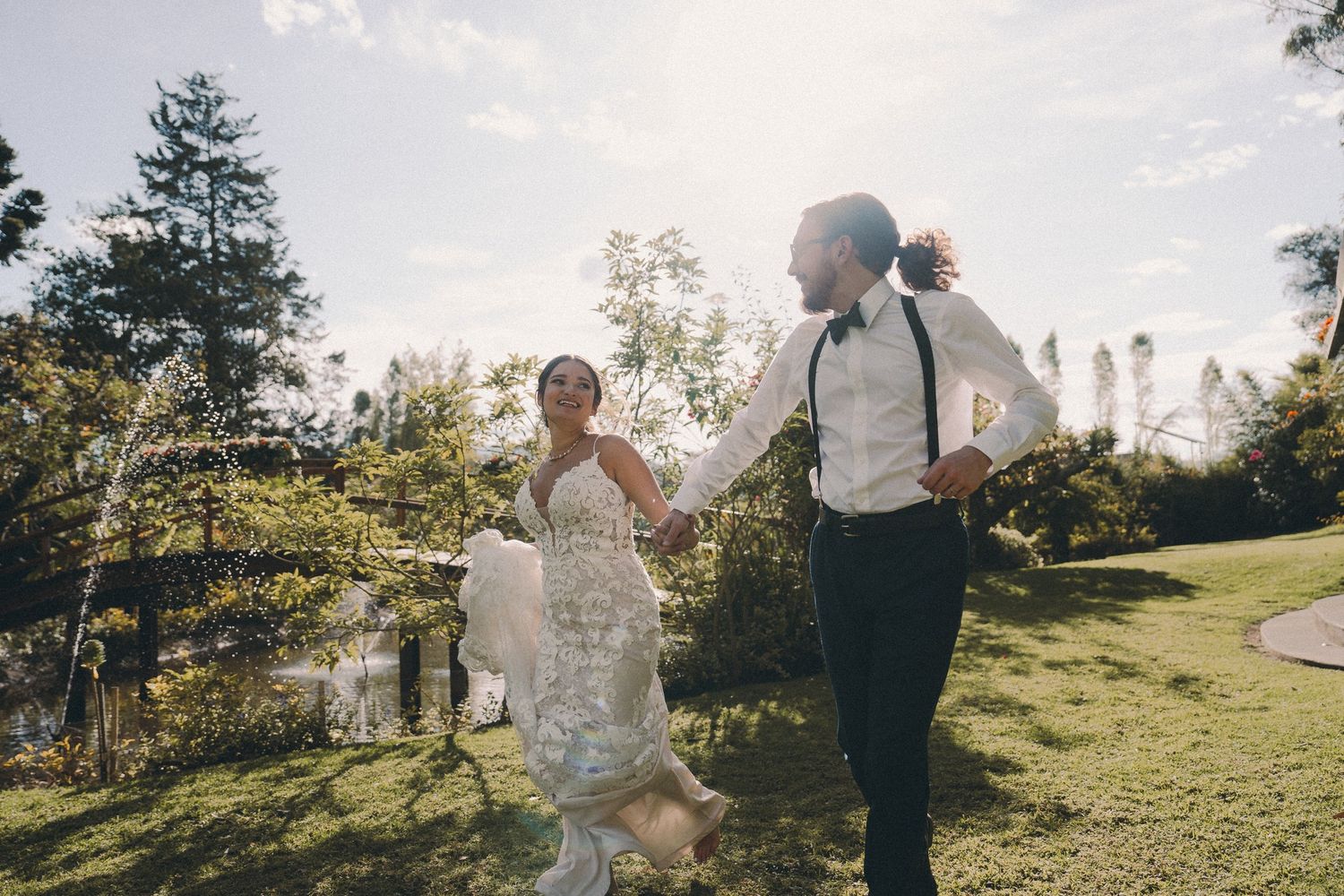 Pareja corriendo feliz en ceremonia de boda en lugar campestre. Quito, Ecuador. Foto por Nath Rivas.