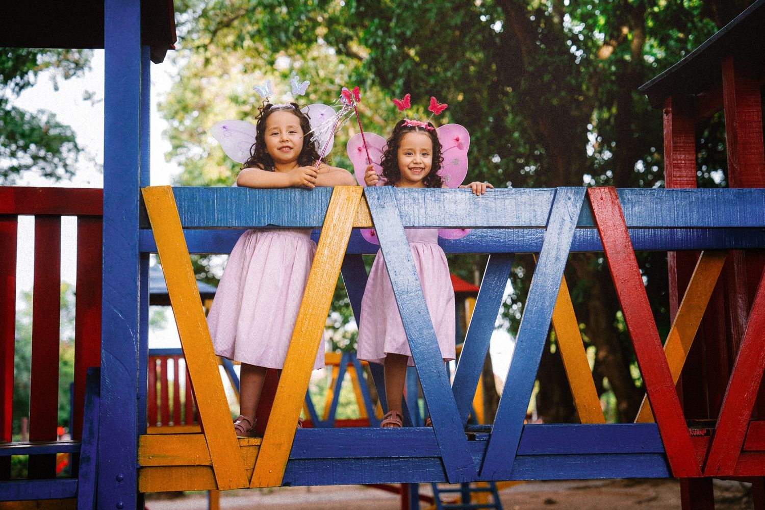 Niñas sonriendo disfrazadas de hadas en parque infantil, celebrando su cumpleaños. Foto por Nath Rivas. Santa Cruz, Bolivia.