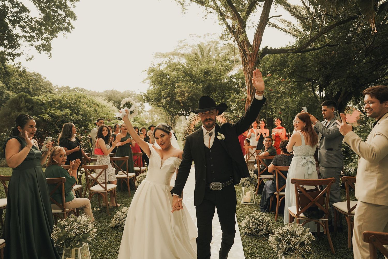 Pareja celebrando su ceremonia íntima de boda estilo vaquero, cowboy, atardecer. Foto por Nath Rivas. Santa Cruz de la Sierra. Casa Jardín.