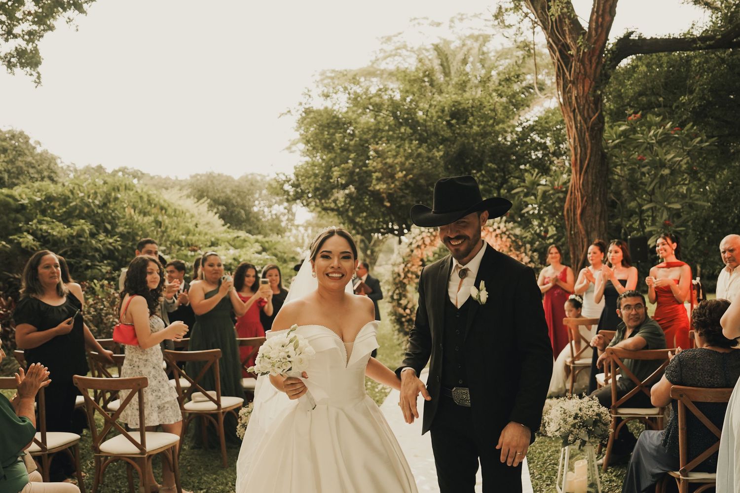 Pareja celebrando su ceremonia íntima de boda estilo vaquero, cowboy, atardecer. Foto por Nath Rivas. Santa Cruz de la Sierra. Casa Jardín.