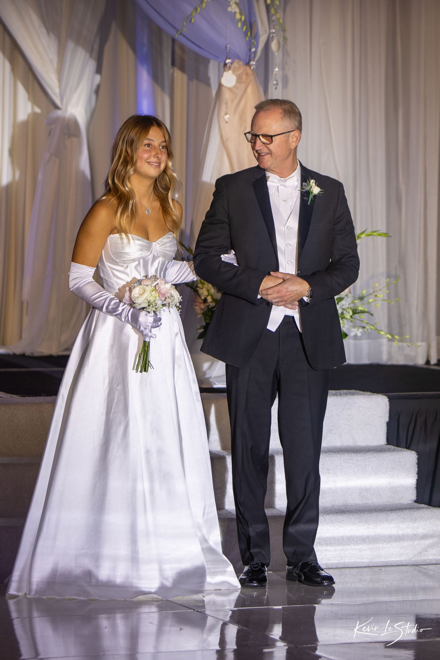 A series of wedding photos showing a couple walking together at their reception with elegant white draping in the background.