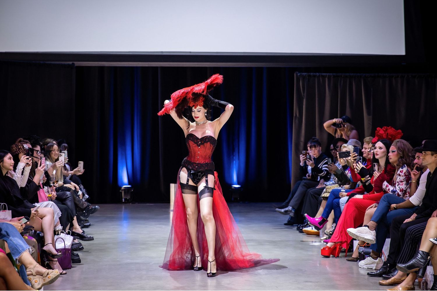 A series of dance performance photos showing dancers in red costumes on a dark stage with blue lighting effects.