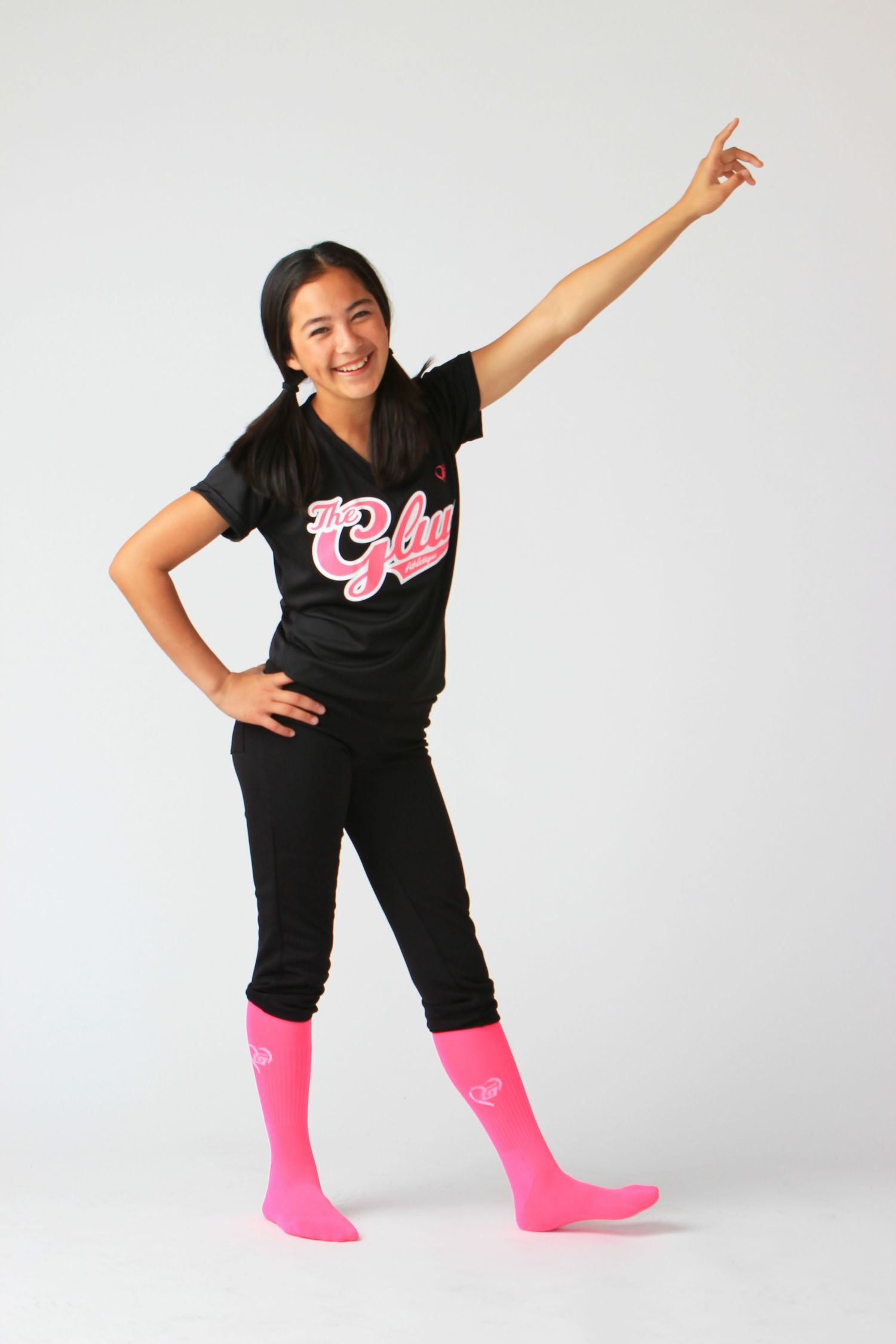 A person in a black t-shirt and bright pink socks poses playfully in three dynamic dance-like positions against a white backdrop.