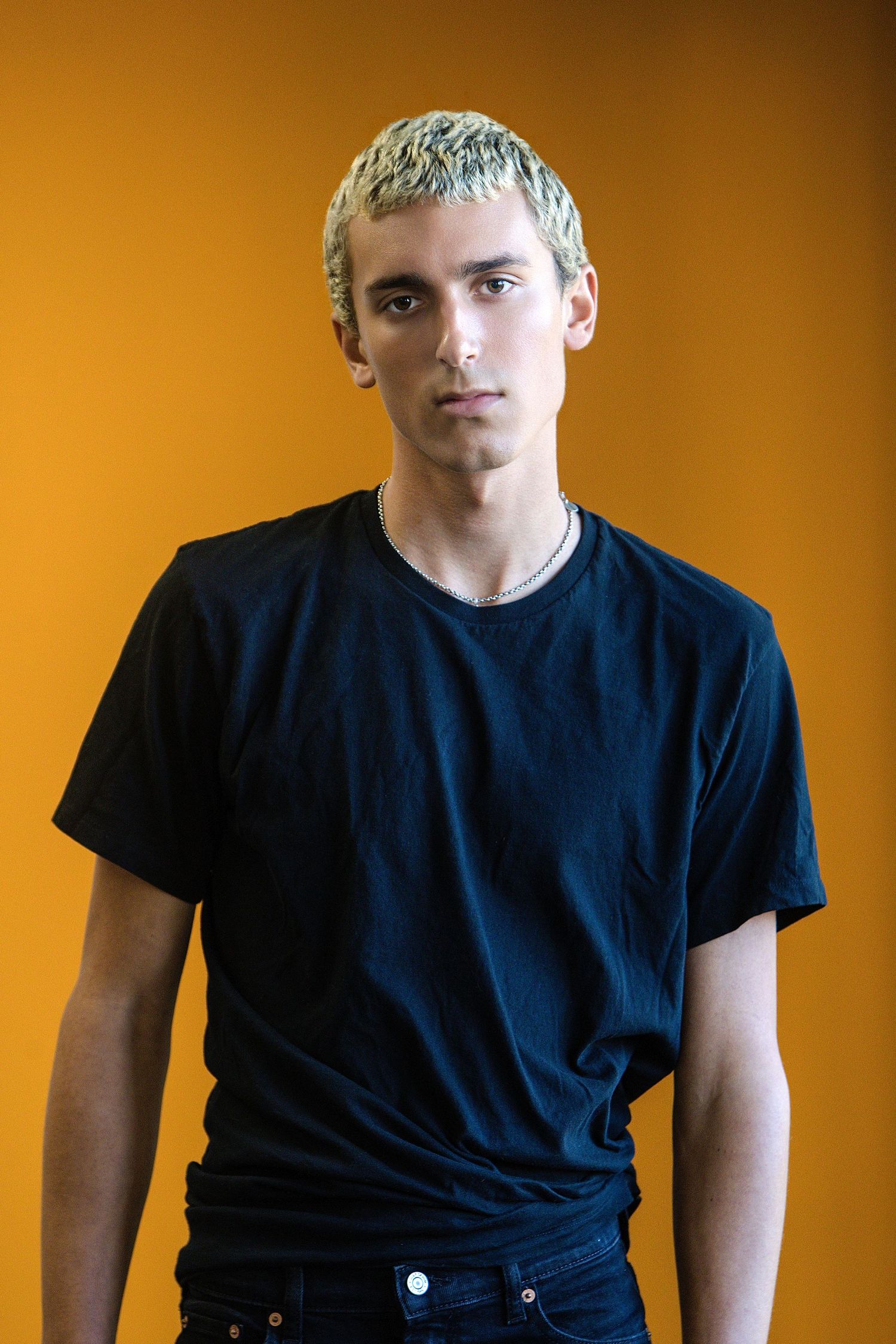 Series of photos showing a person in a black t-shirt against an orange background in different poses.
