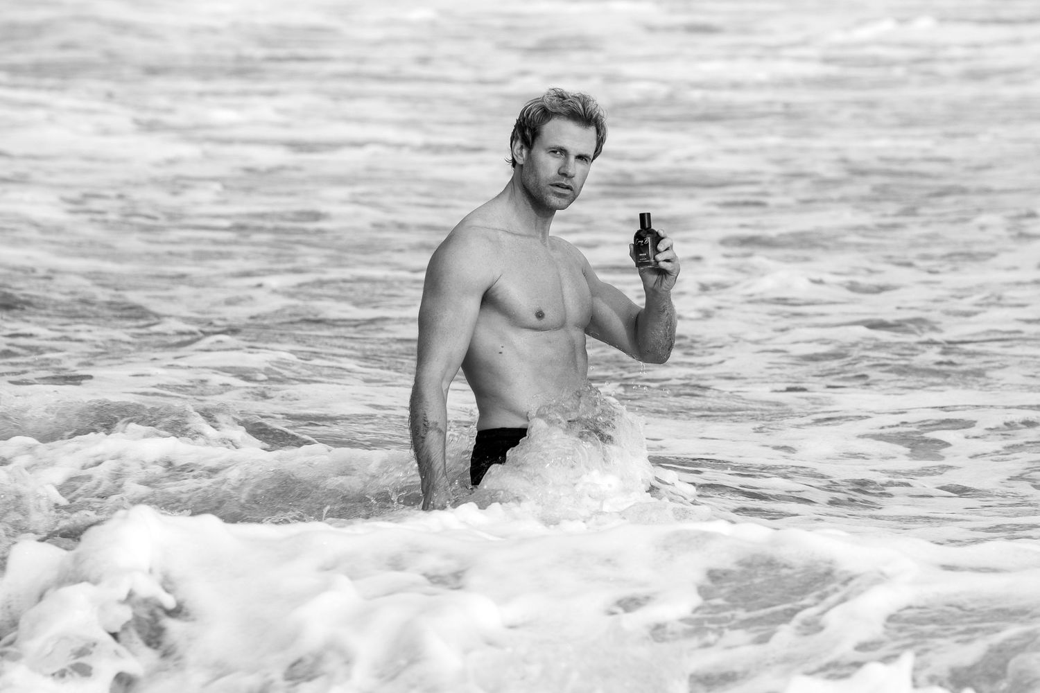 A person emerges from ocean waves while swimming in rough surf at the beach.